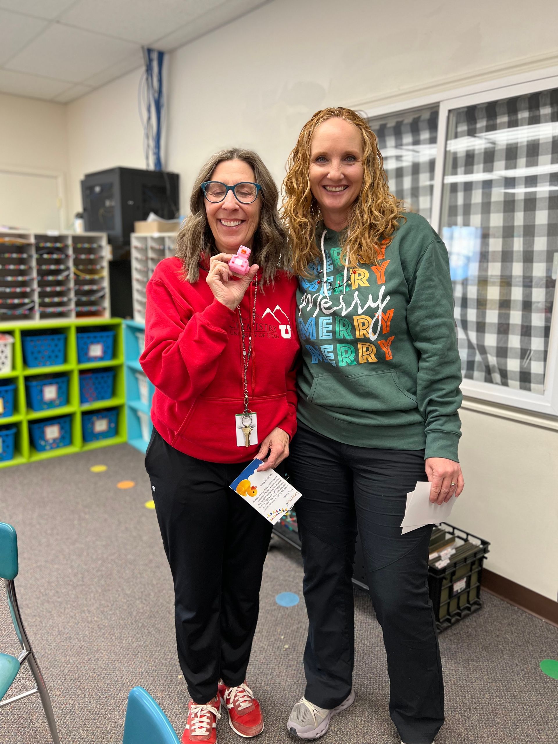 Two women are standing next to each other in a classroom.