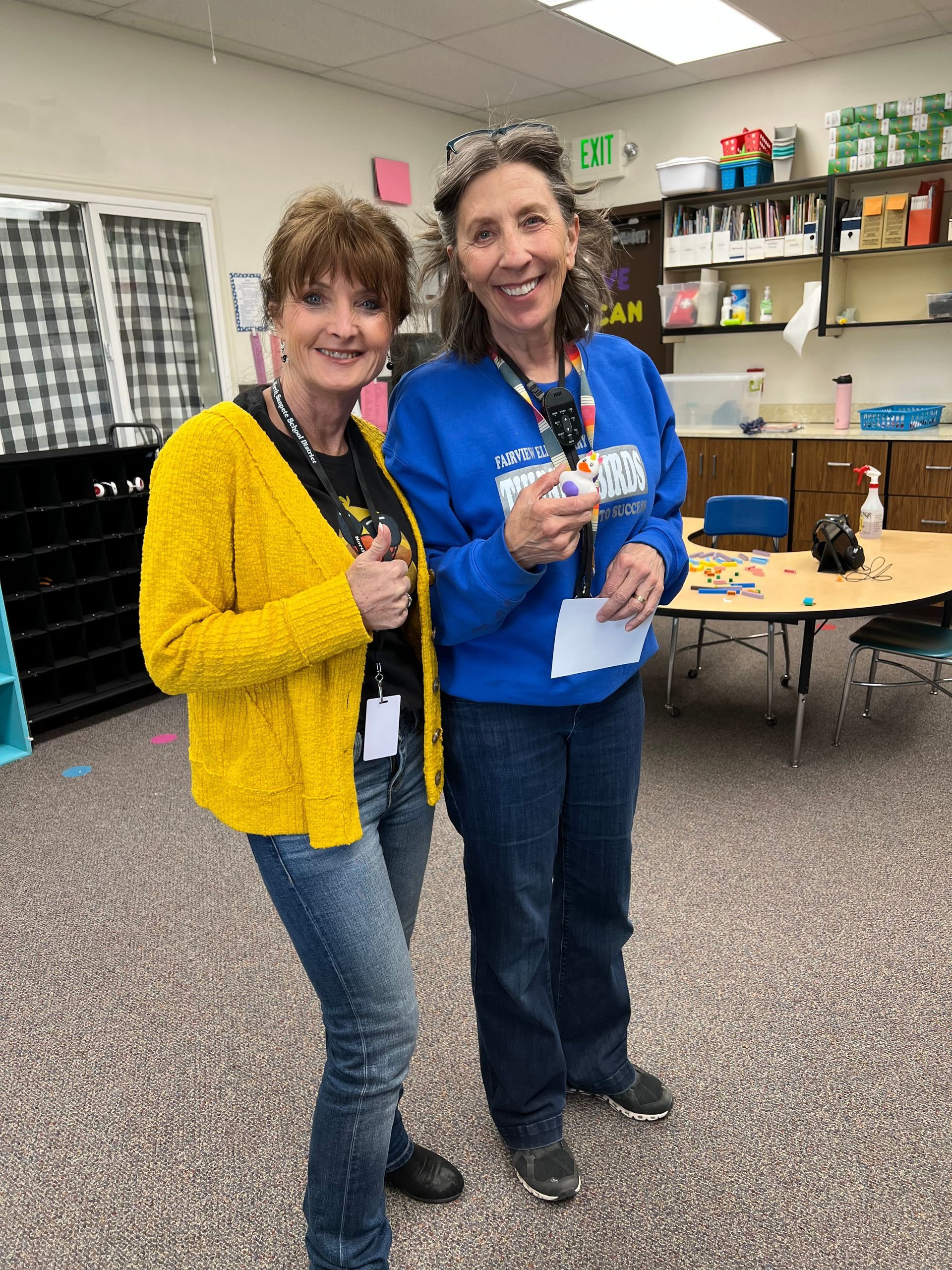 Two women are standing next to each other in a classroom.