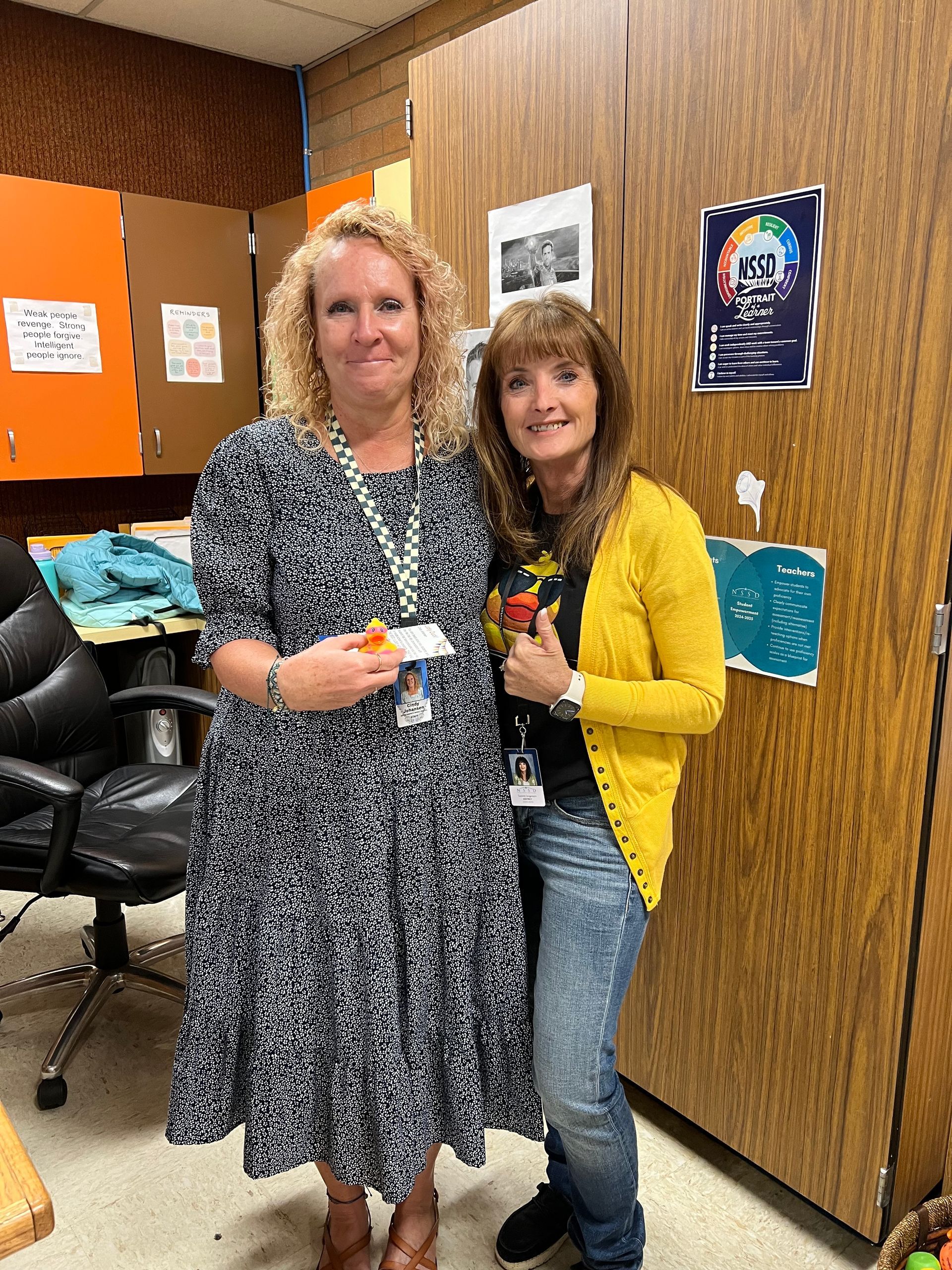 Two women are standing next to each other in a room.