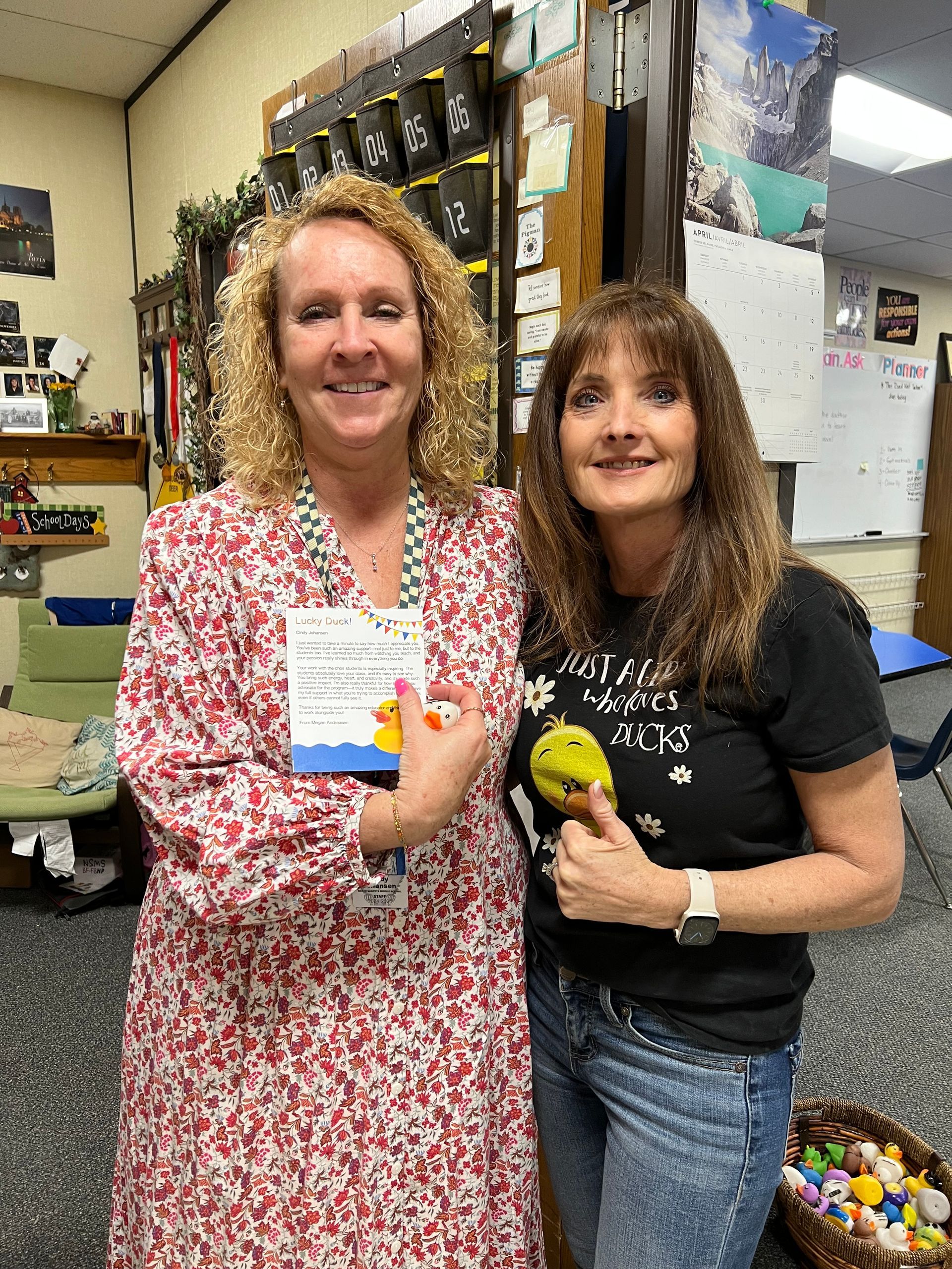 Two women are standing next to each other in a room holding ice cream cones.