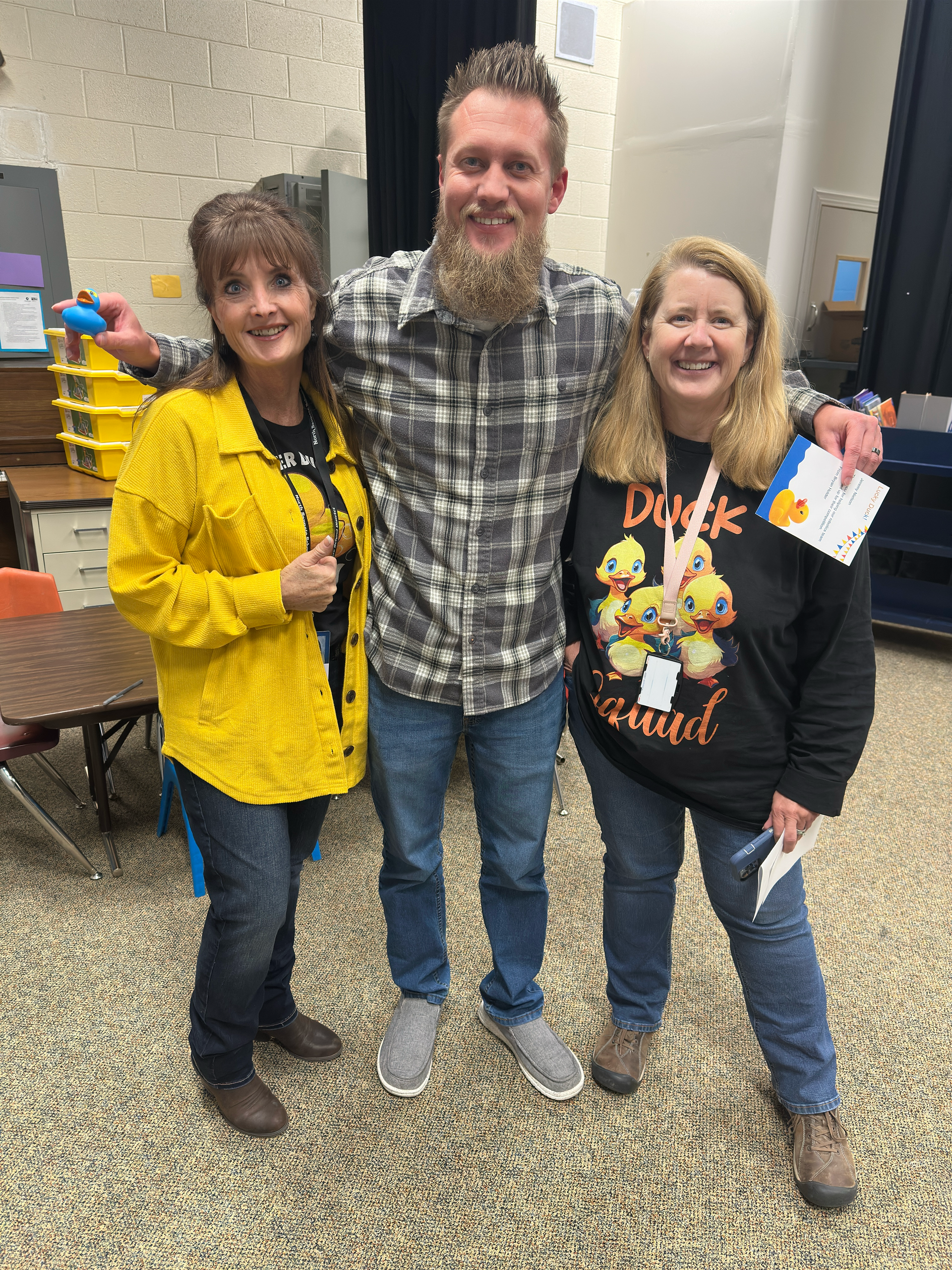 A man with a beard is posing for a picture with two women.