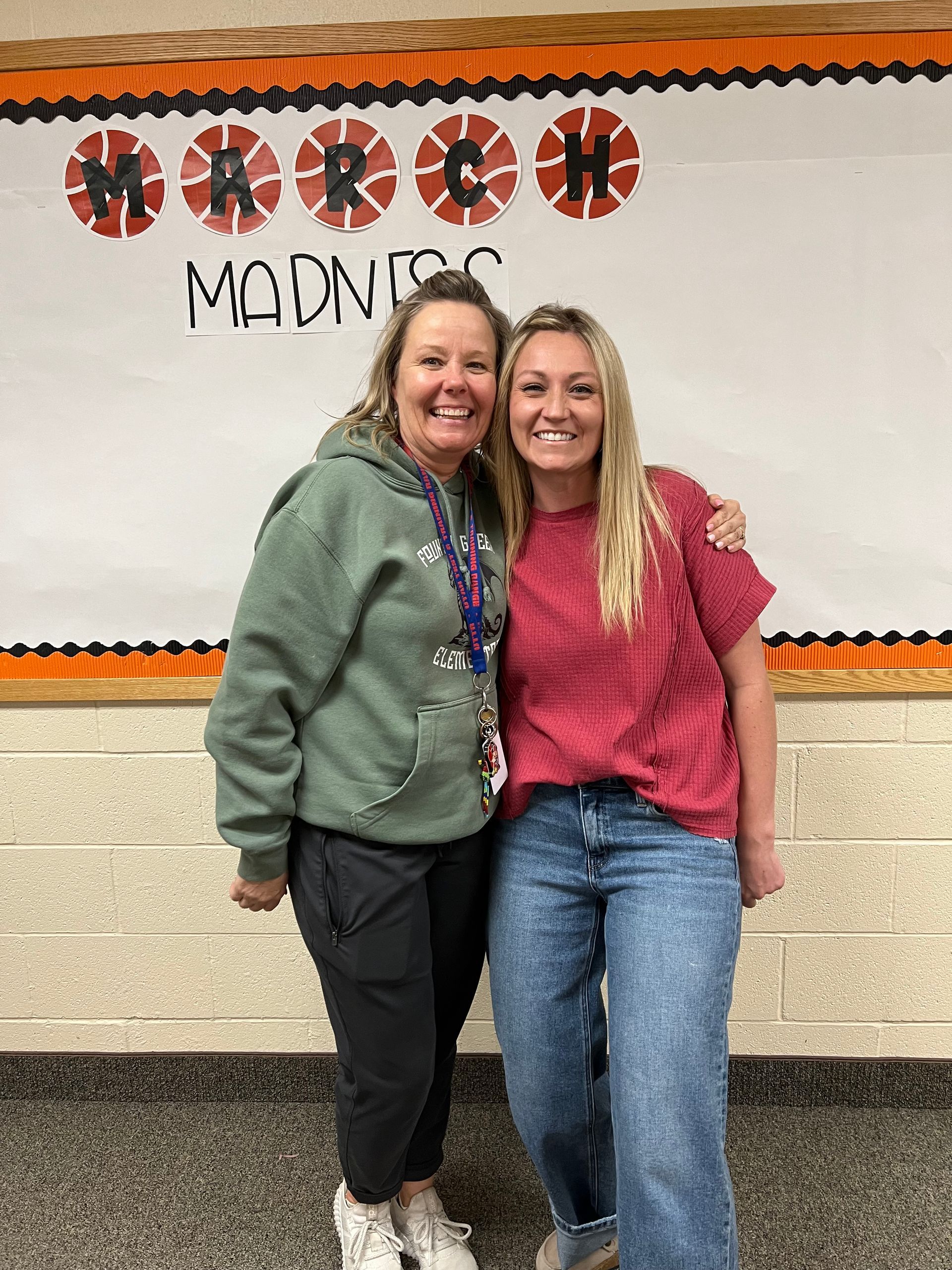 Two women pose in front of a 