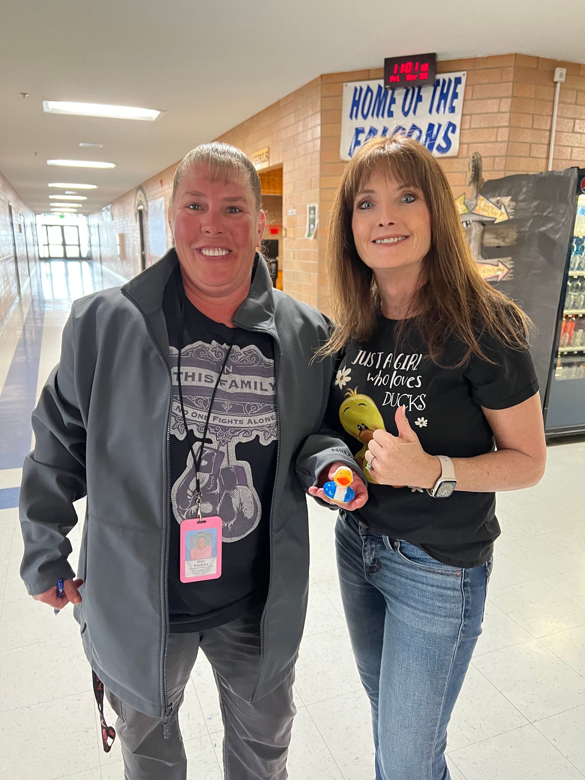 A man and a woman are posing for a picture in a hallway.