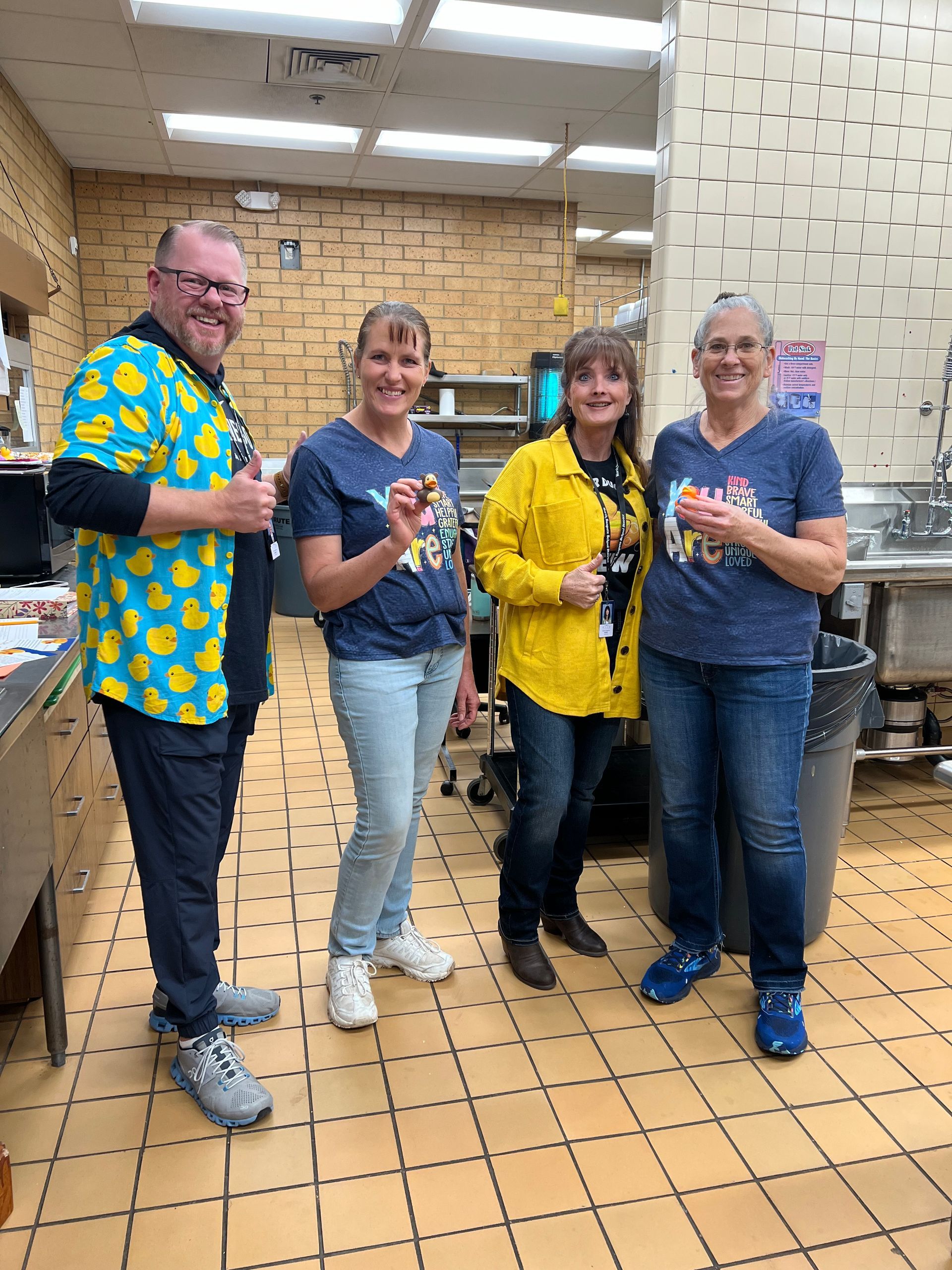 A group of people are standing next to each other in a kitchen.