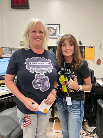 Two women are standing next to each other in an office.