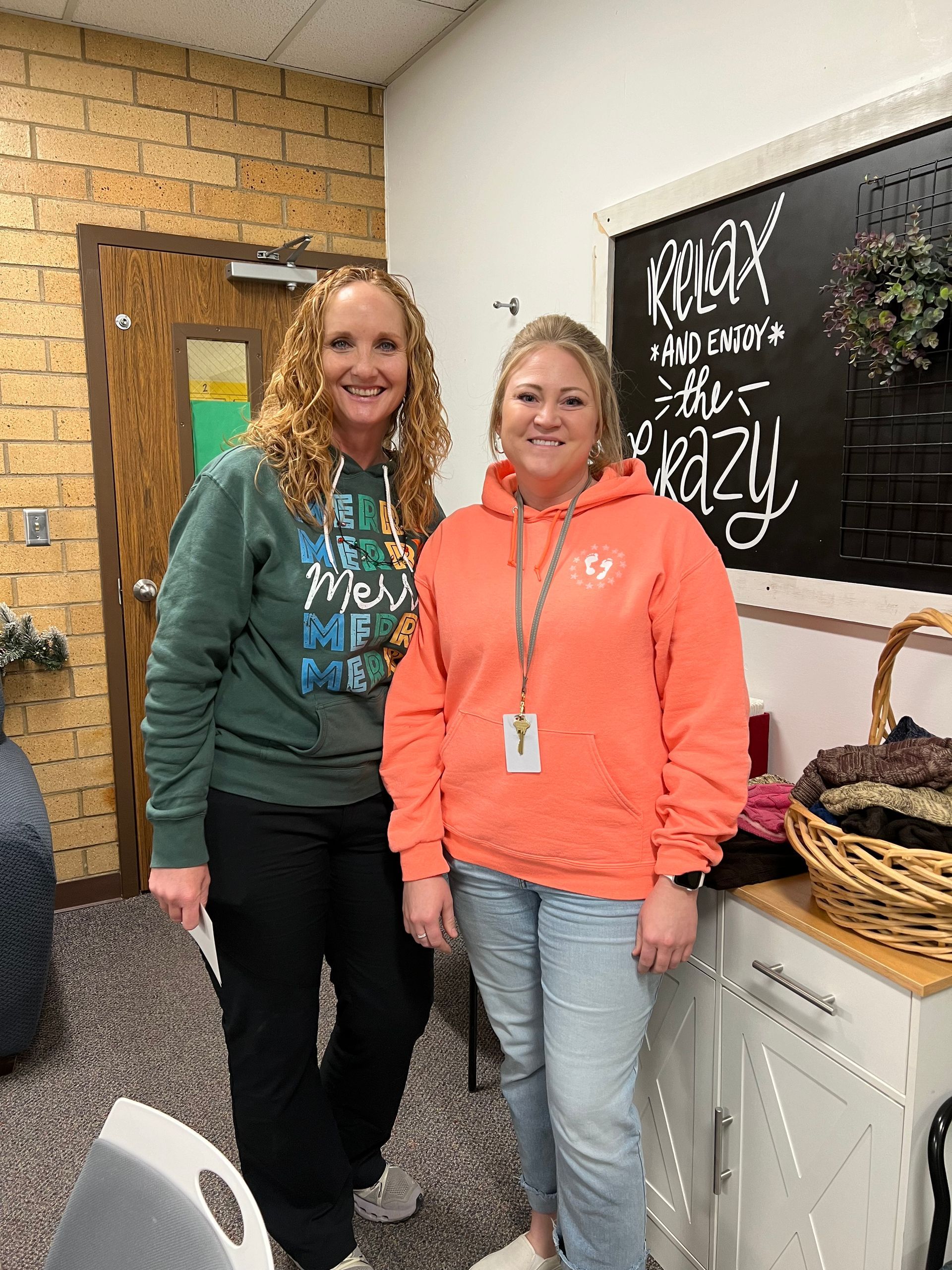 Two women are standing next to each other in a room.