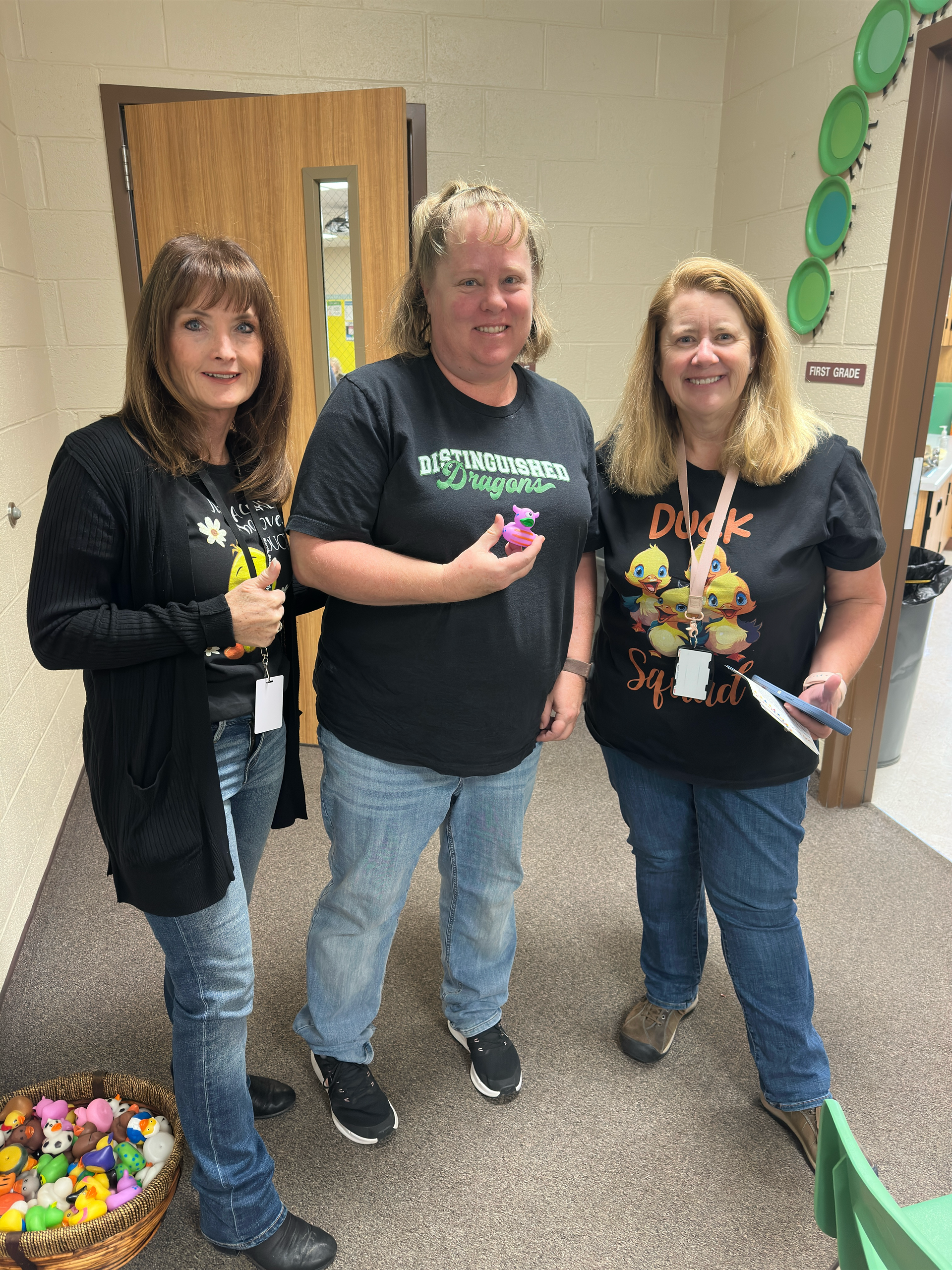 Three women are standing next to each other in a room.