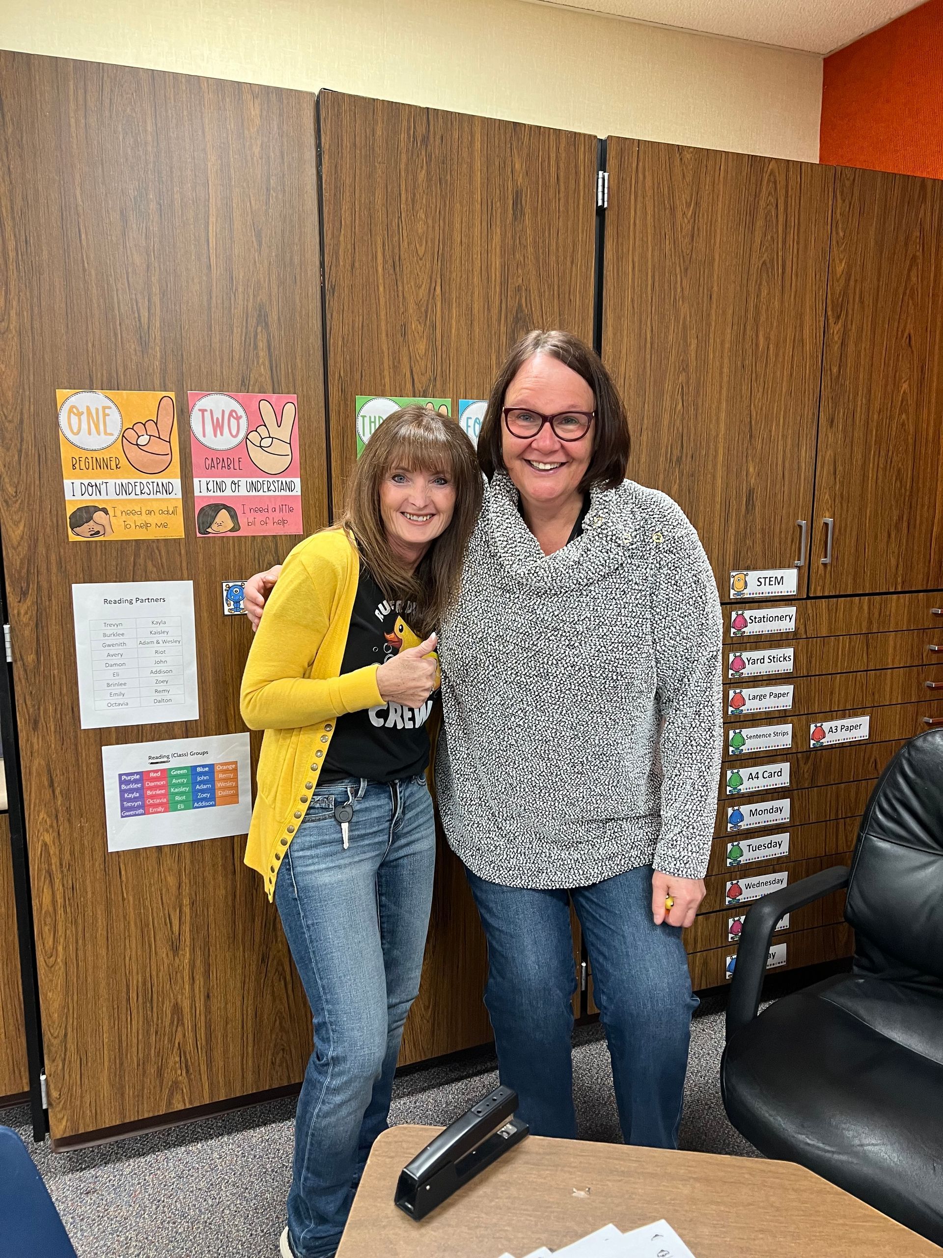 Two women are posing for a picture in a room.