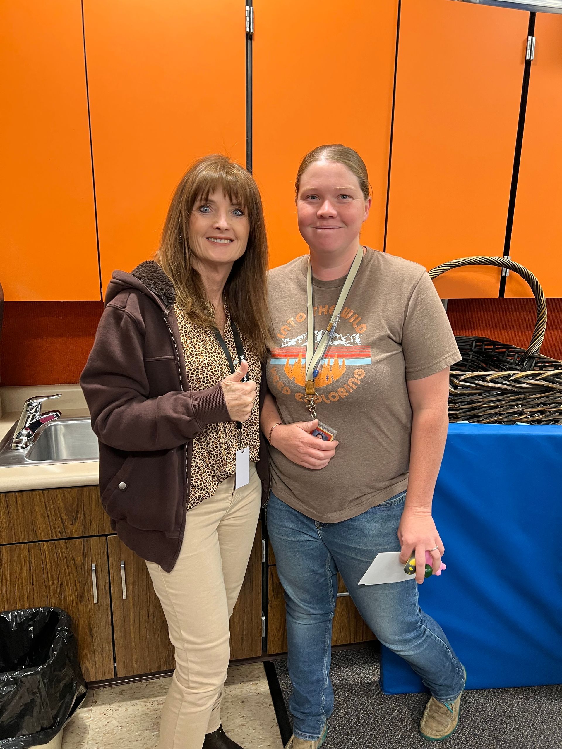 Two women are standing next to each other in a kitchen.