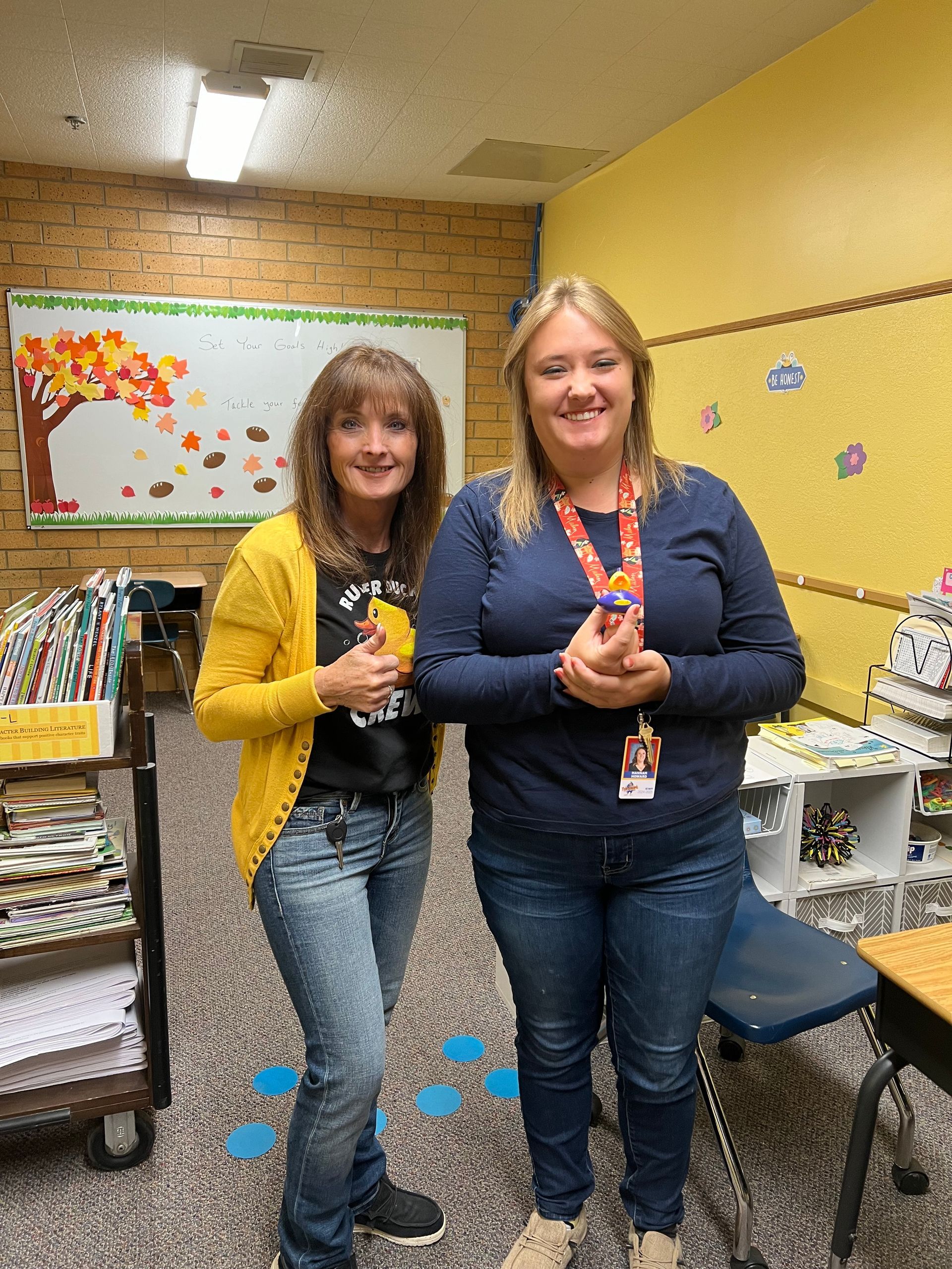 Two women are standing next to each other in a classroom.