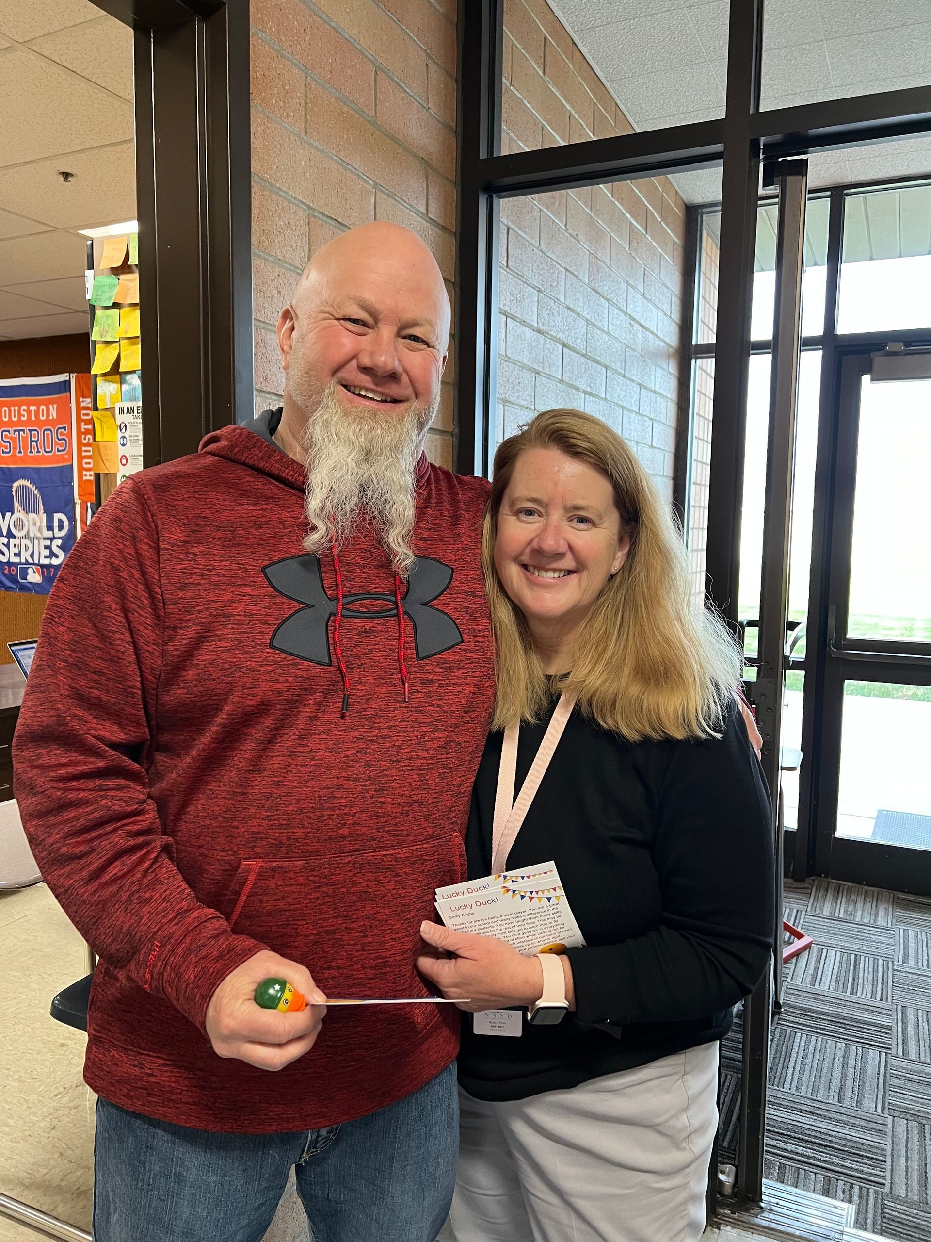 A man with a beard is standing next to a woman holding a screwdriver.