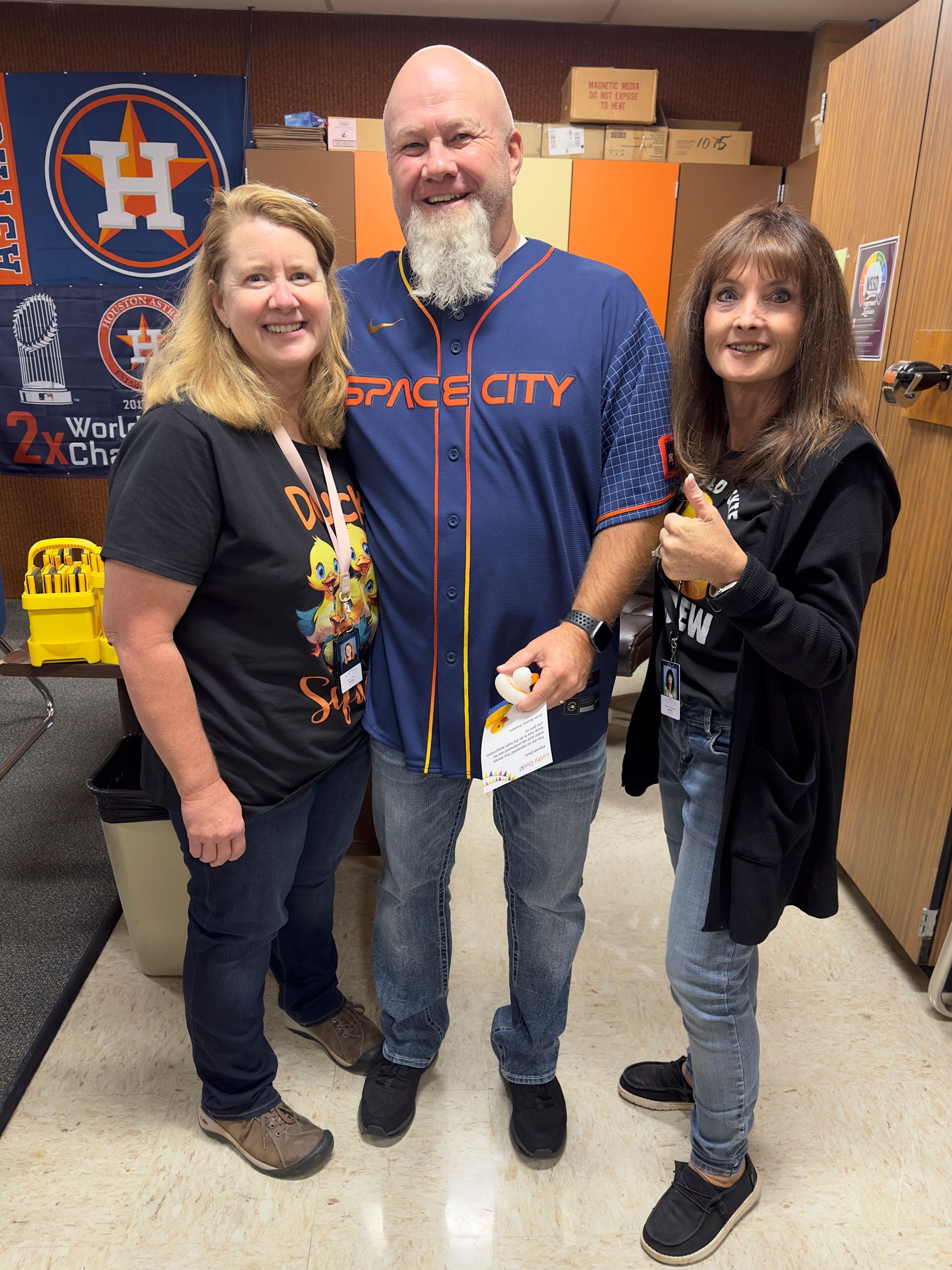 A man wearing a space city jersey poses with two women