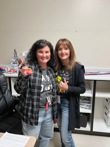 Two women are standing next to each other in a room.