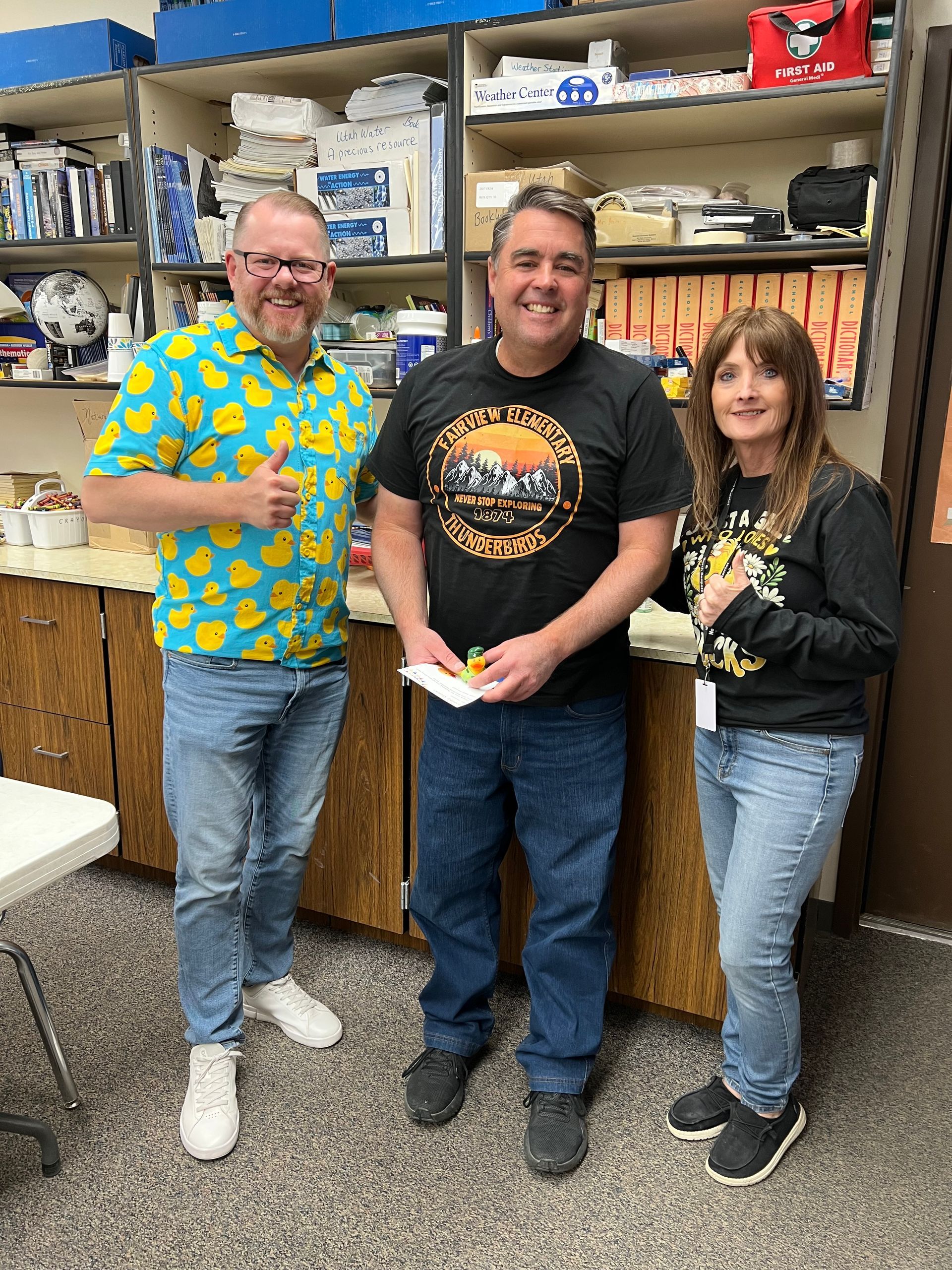 Three people are standing next to each other in a room.