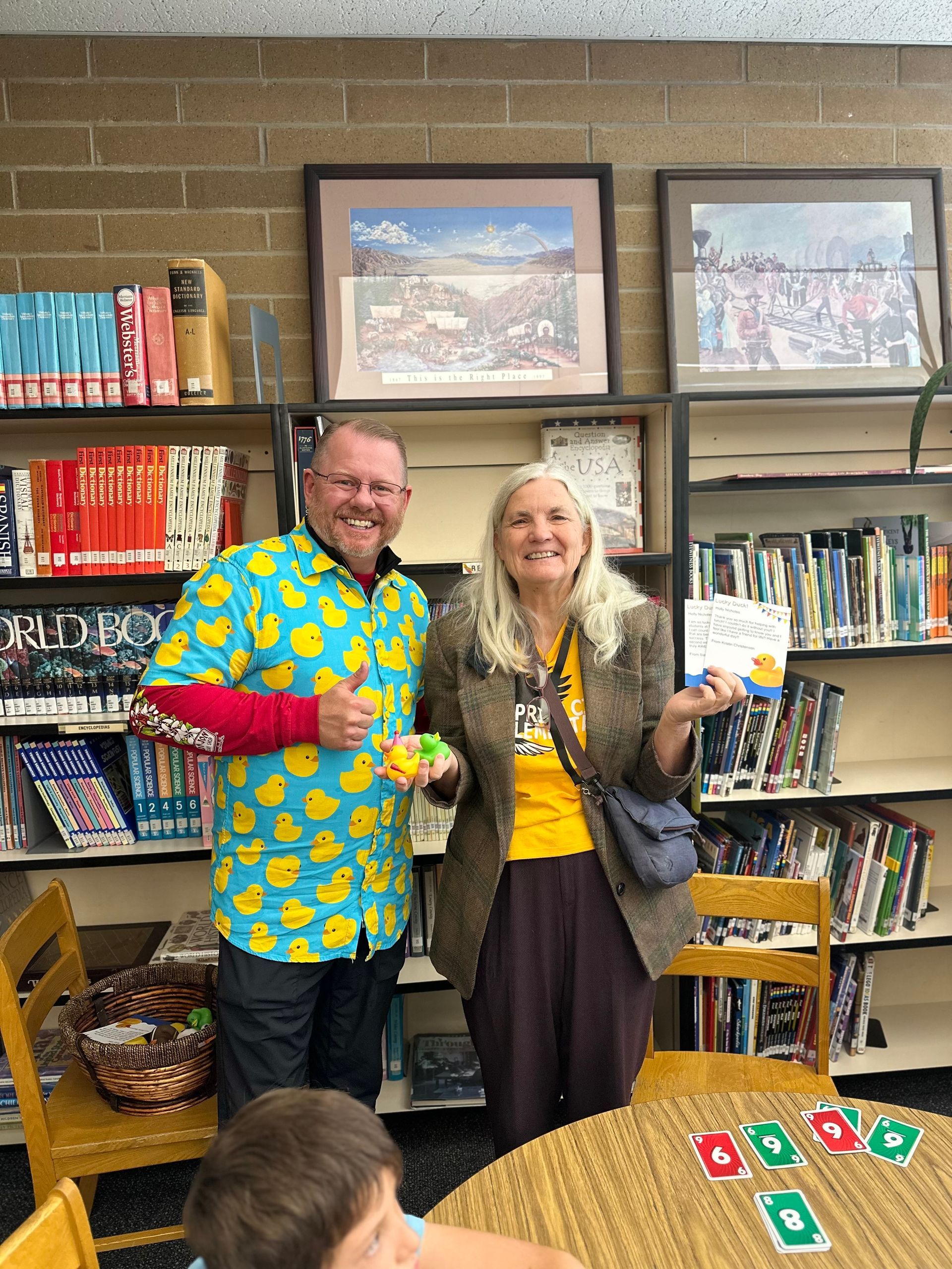 A man and a woman are standing next to each other in a library.