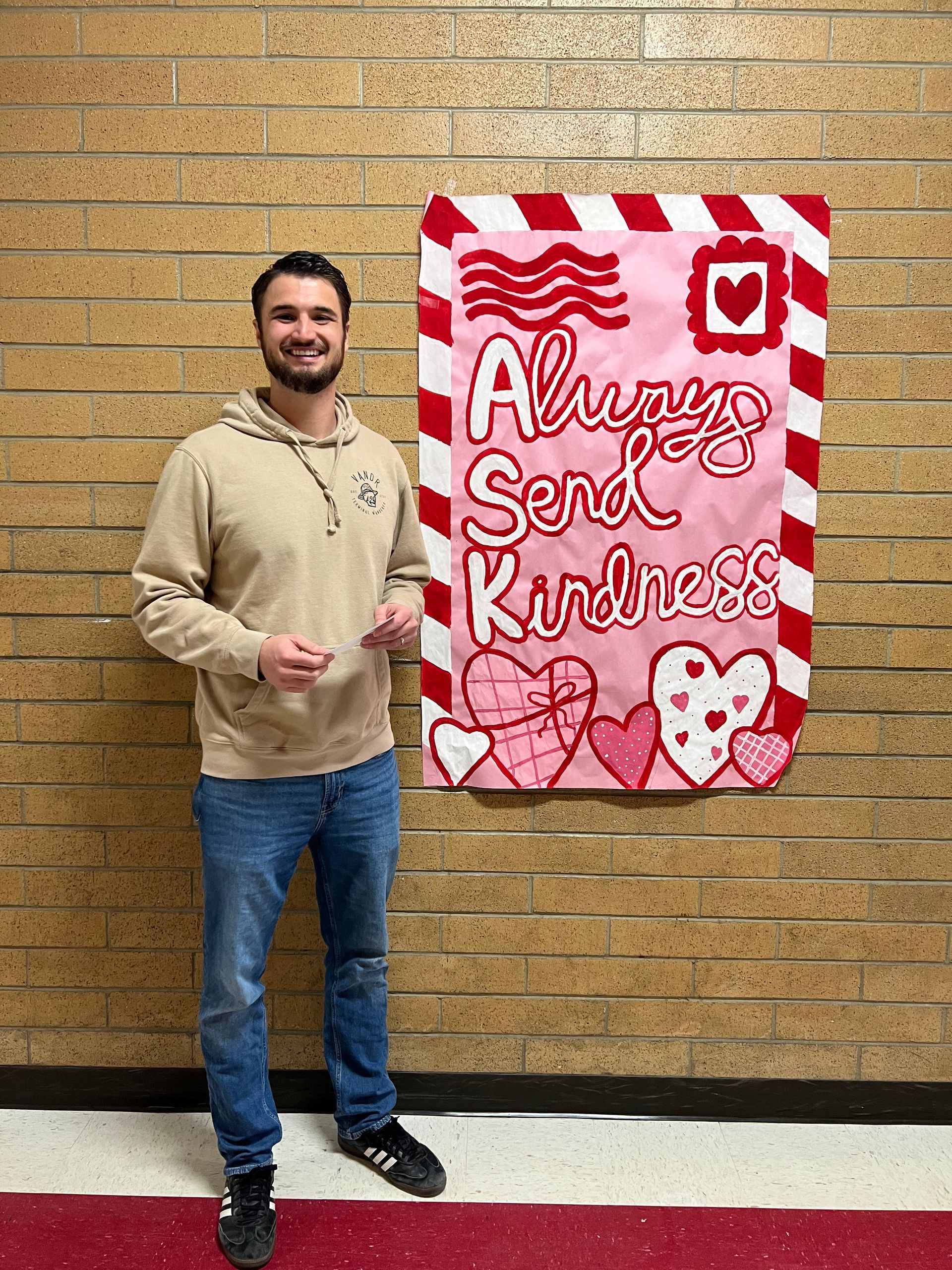 Man standing next to a poster that says 