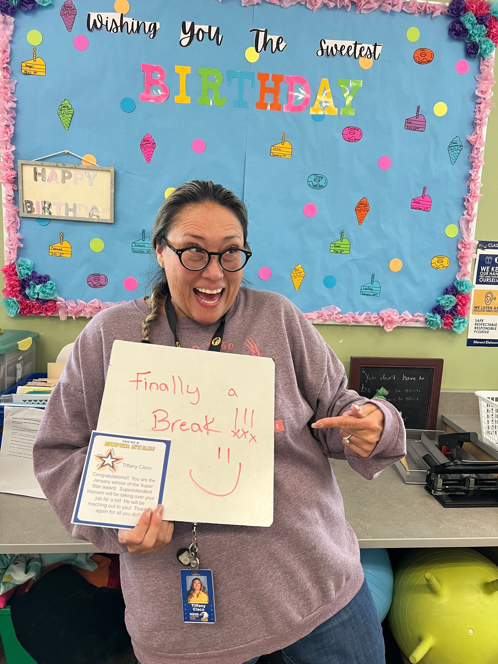 Woman smiling, holding whiteboard saying 