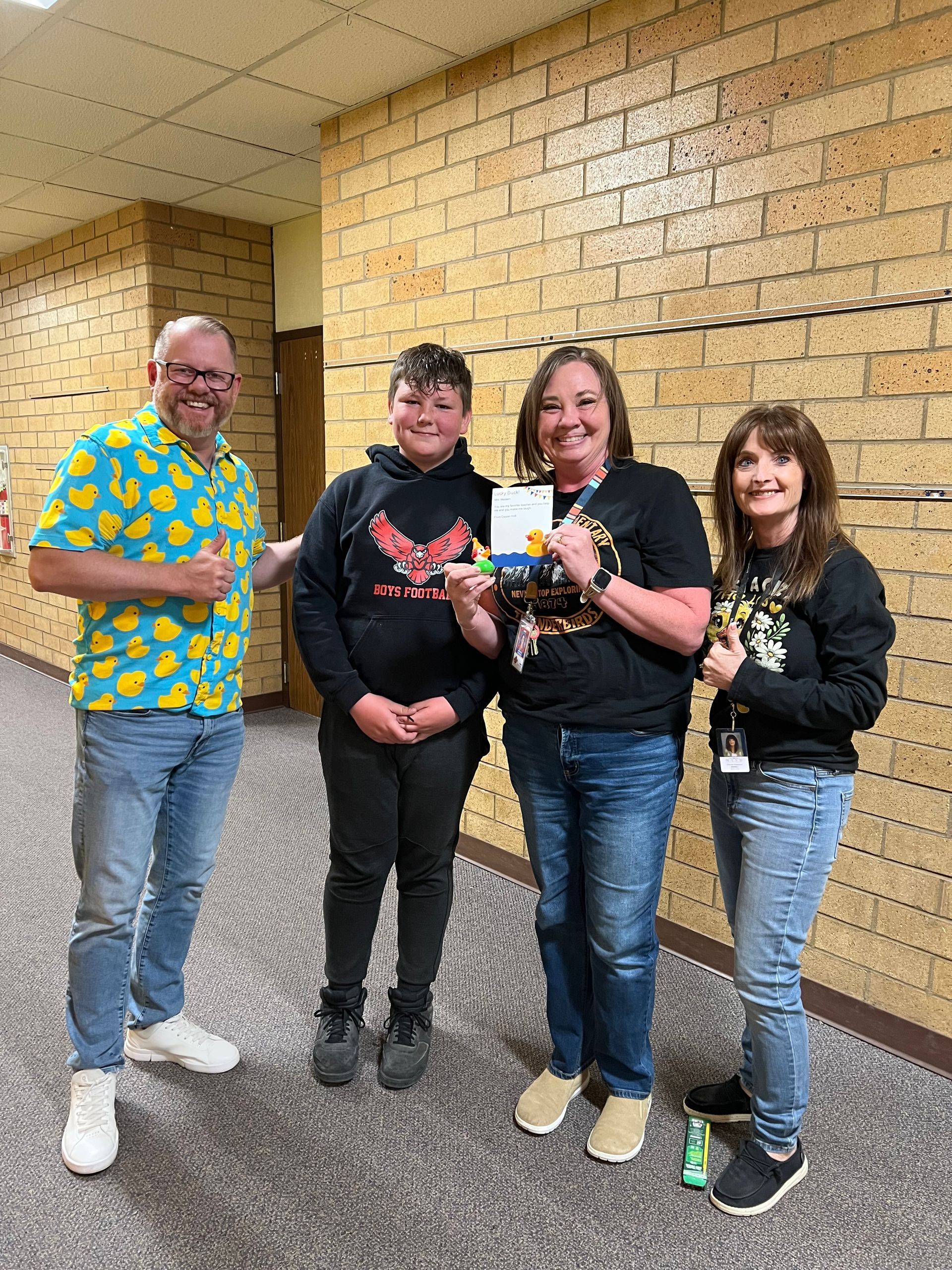 A group of people are standing next to each other in a hallway.