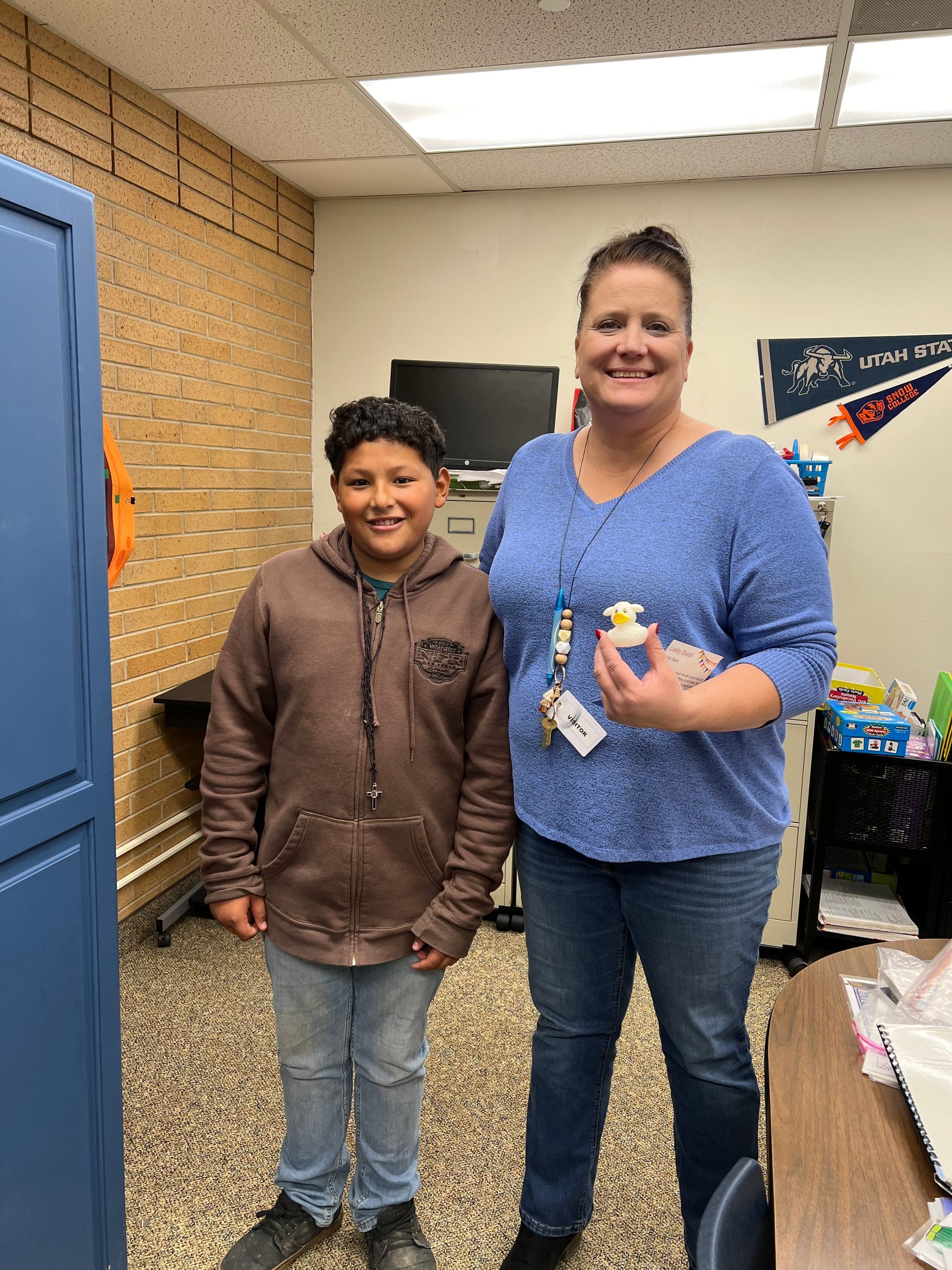 A woman and a boy are standing next to each other in a room.