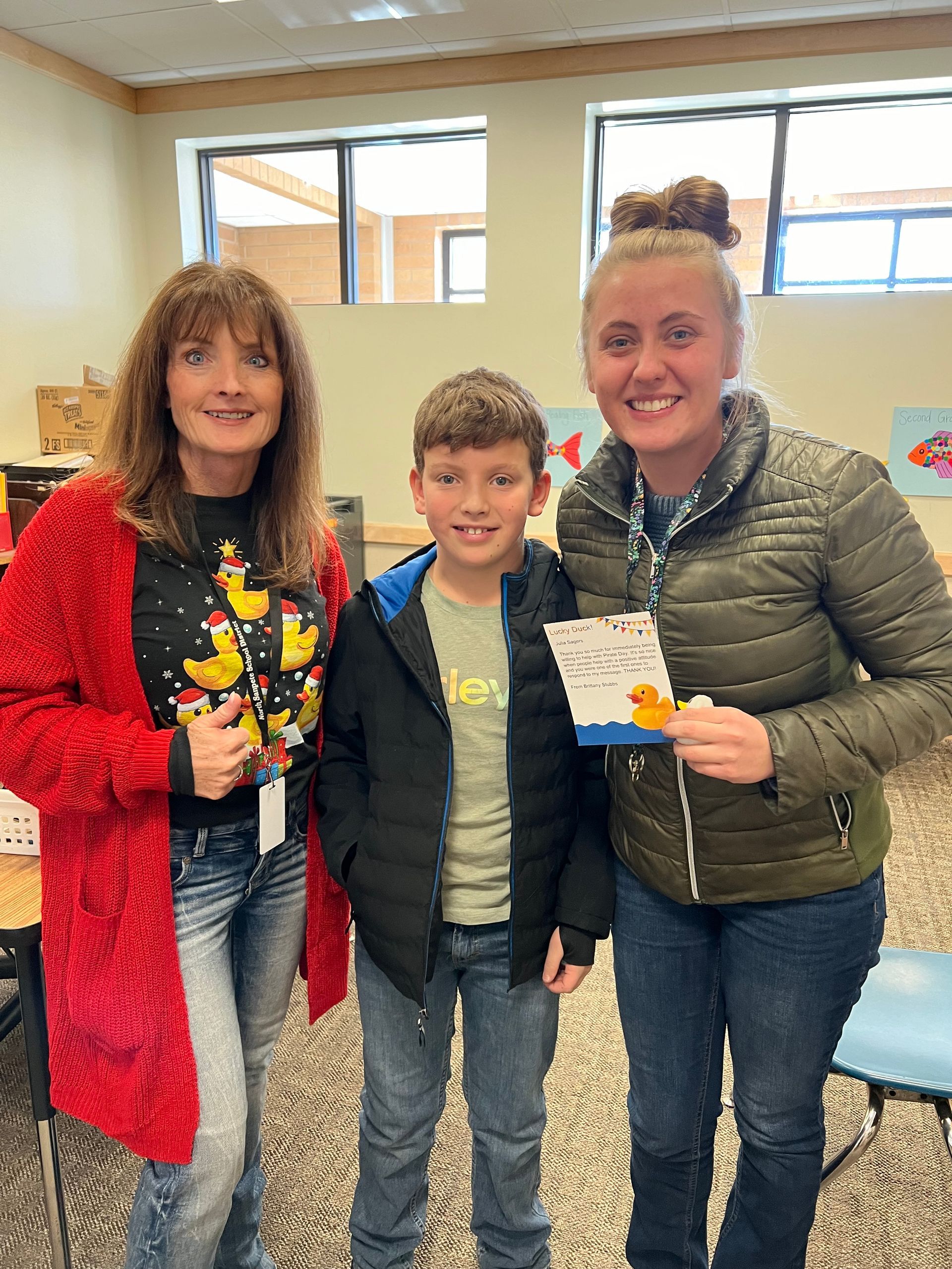 Two women and a boy are posing for a picture in a room.