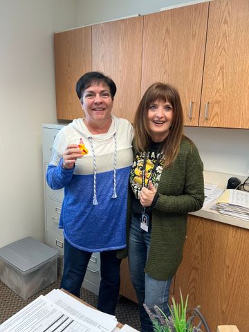 Two women are standing next to each other in a kitchen.