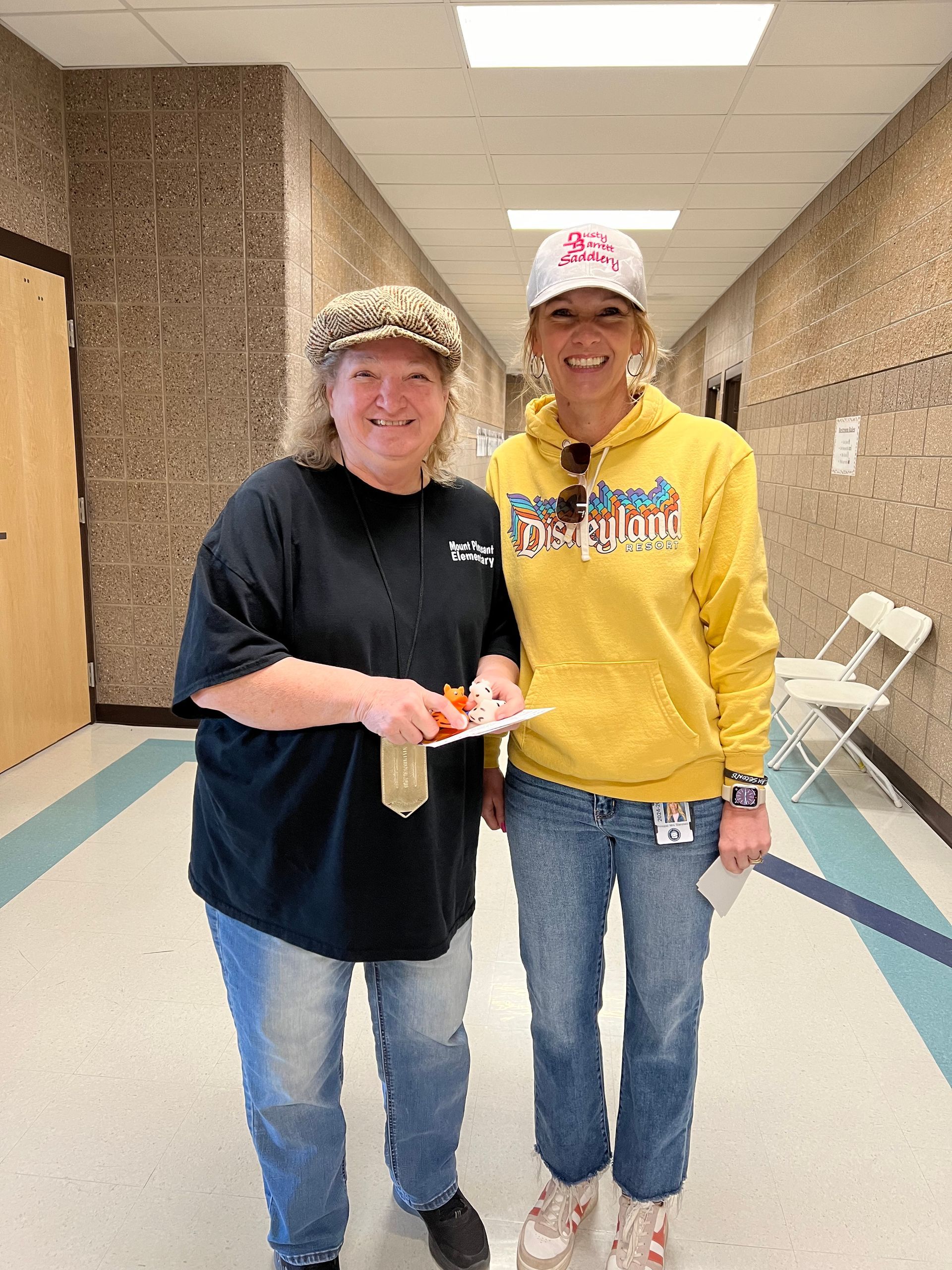 Two women are standing next to each other in a hallway.