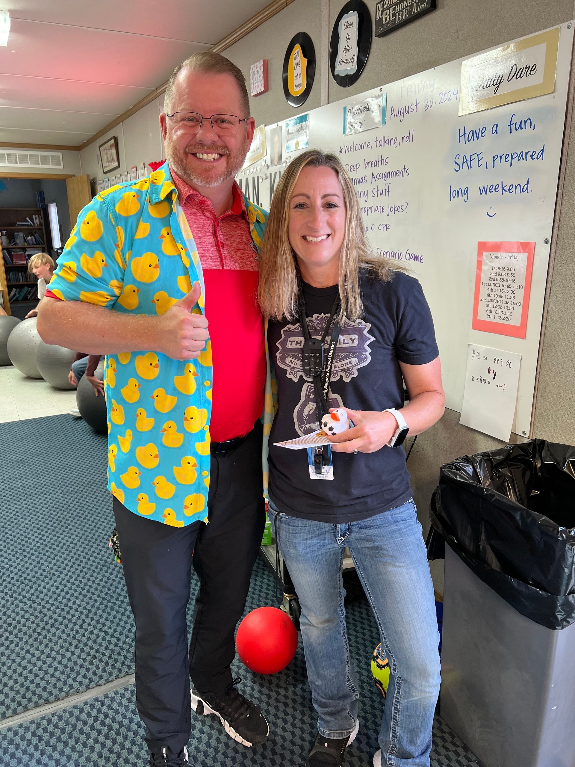 A man in a duck shirt is standing next to a woman in a black shirt.