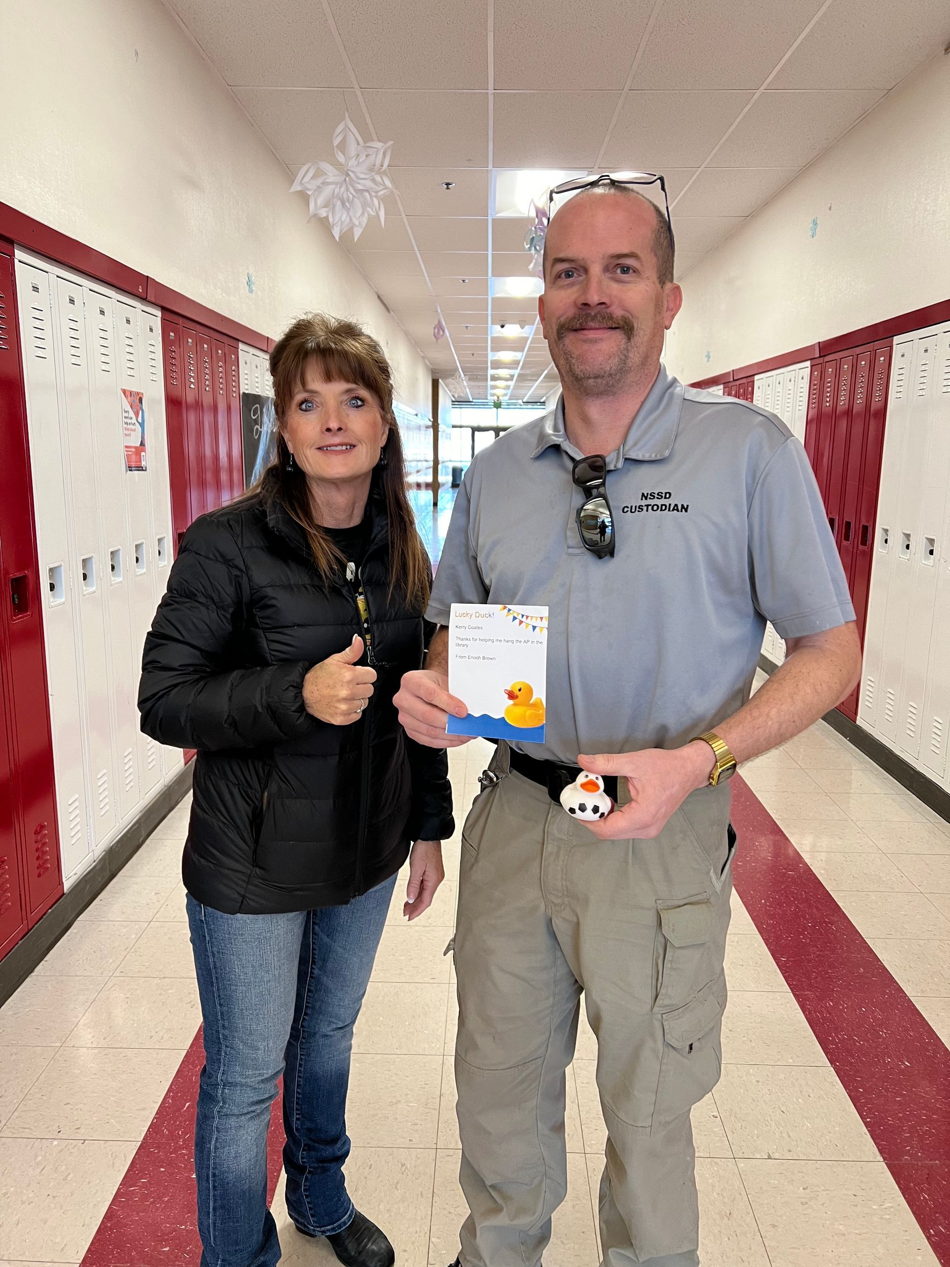 A man and a woman are standing next to each other in a hallway.