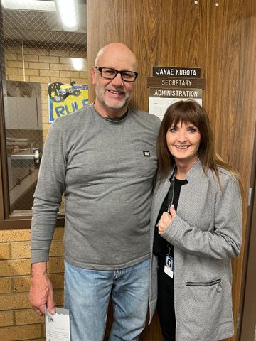 A man and a woman are posing for a picture in front of a door.