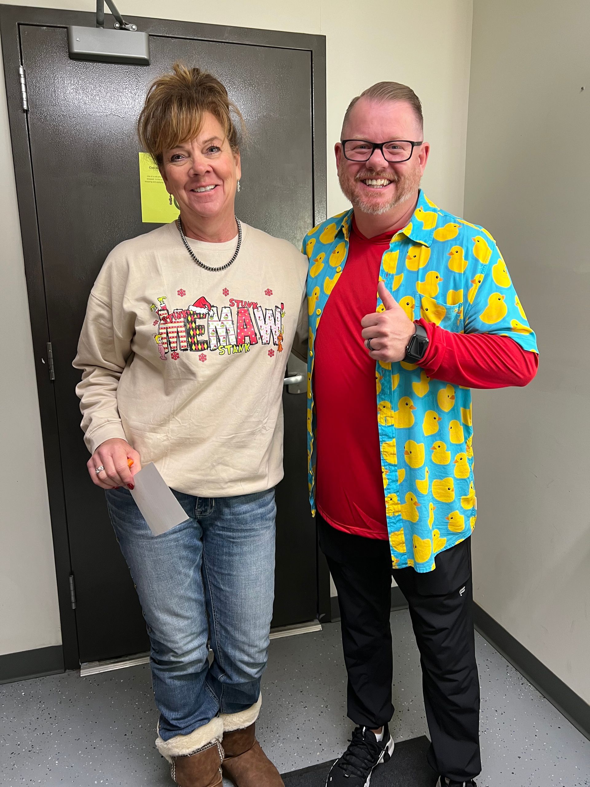 A man and a woman are standing next to each other in a hallway.