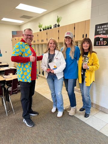 A group of people are standing next to each other in a classroom.