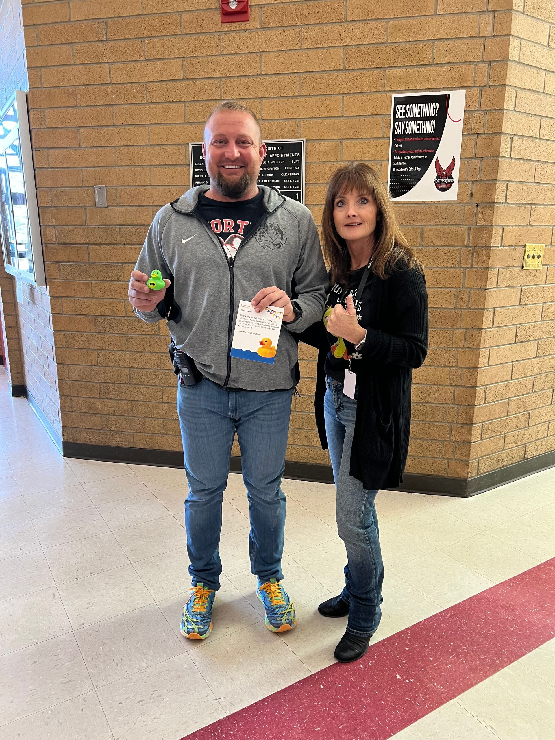 A man and a woman are standing next to each other in a hallway.