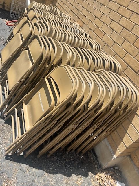 A bunch of folding chairs are stacked on top of each other