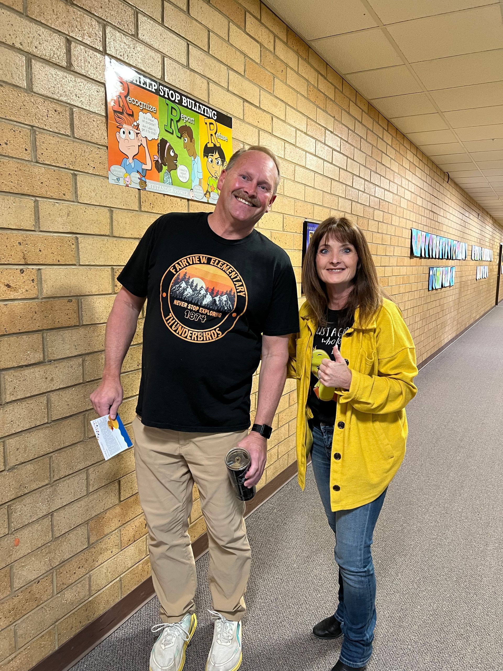 A man and a woman are standing next to each other in a hallway.