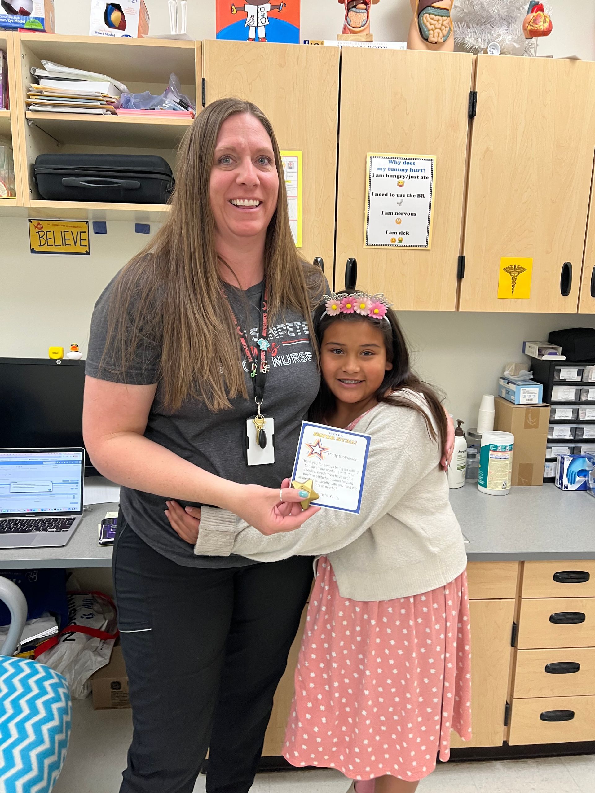 Teacher presenting a certificate to a smiling student in a classroom