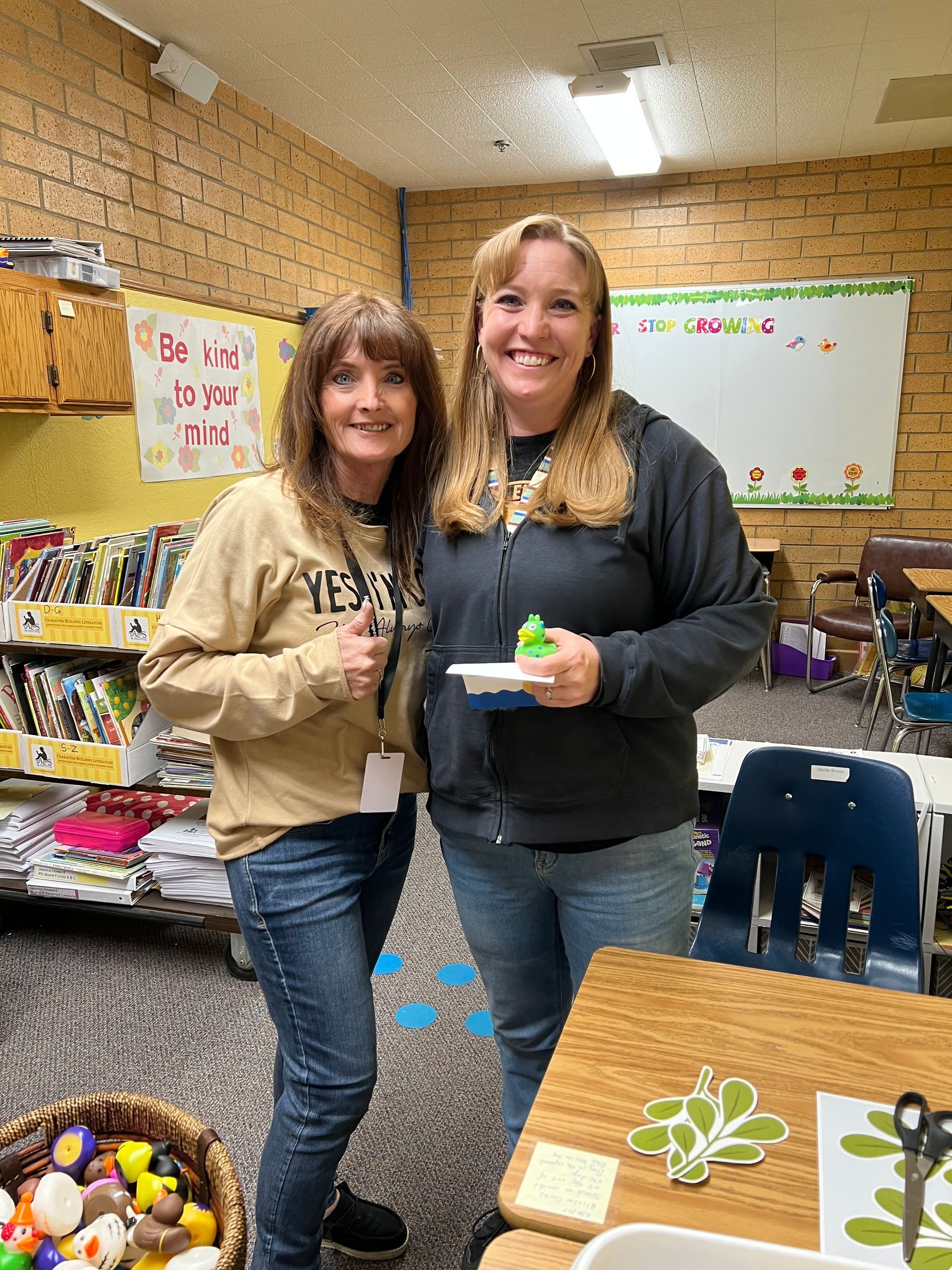 Two women are standing next to each other in a classroom.