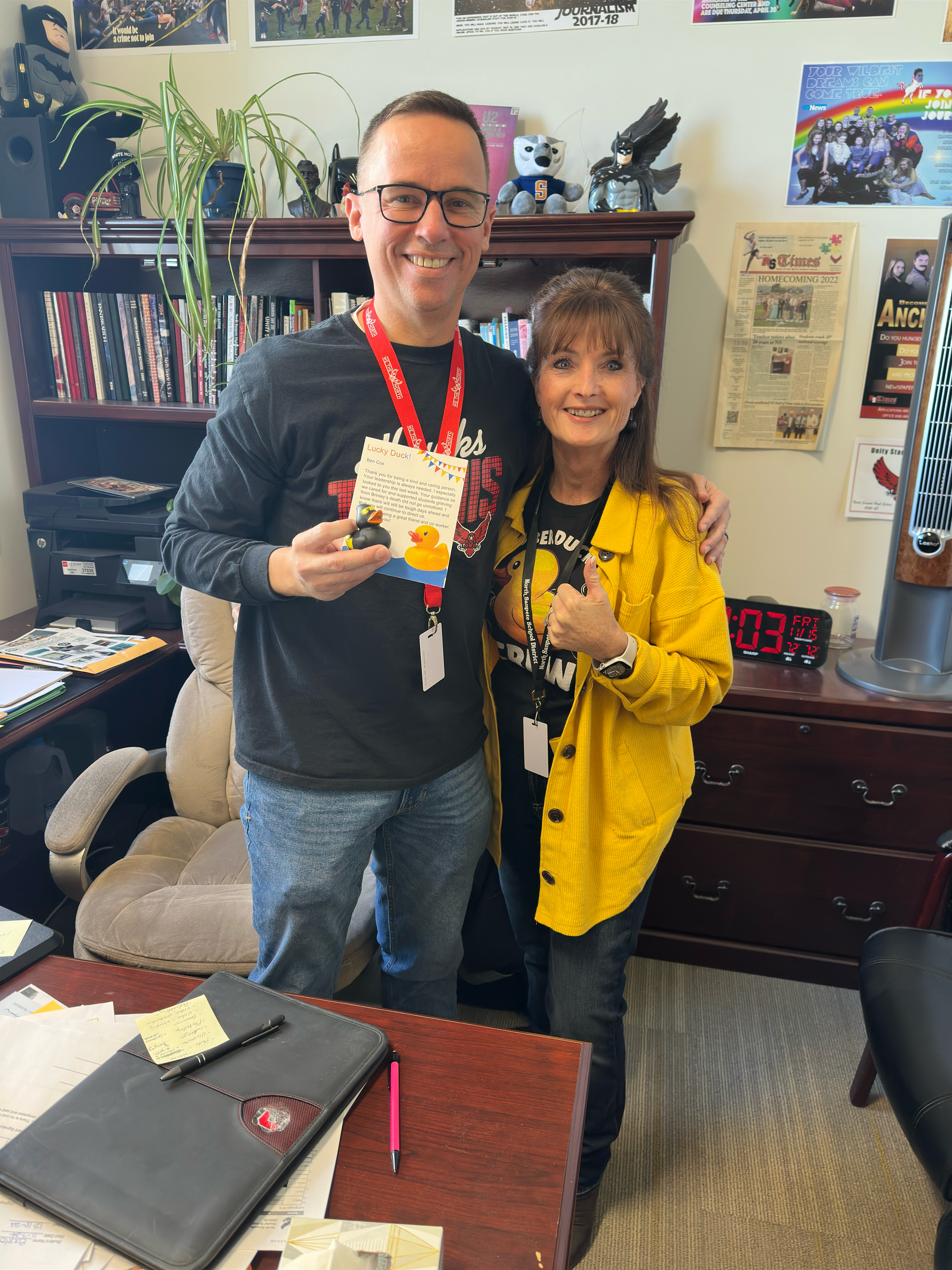 A man and a woman are posing for a picture in an office.