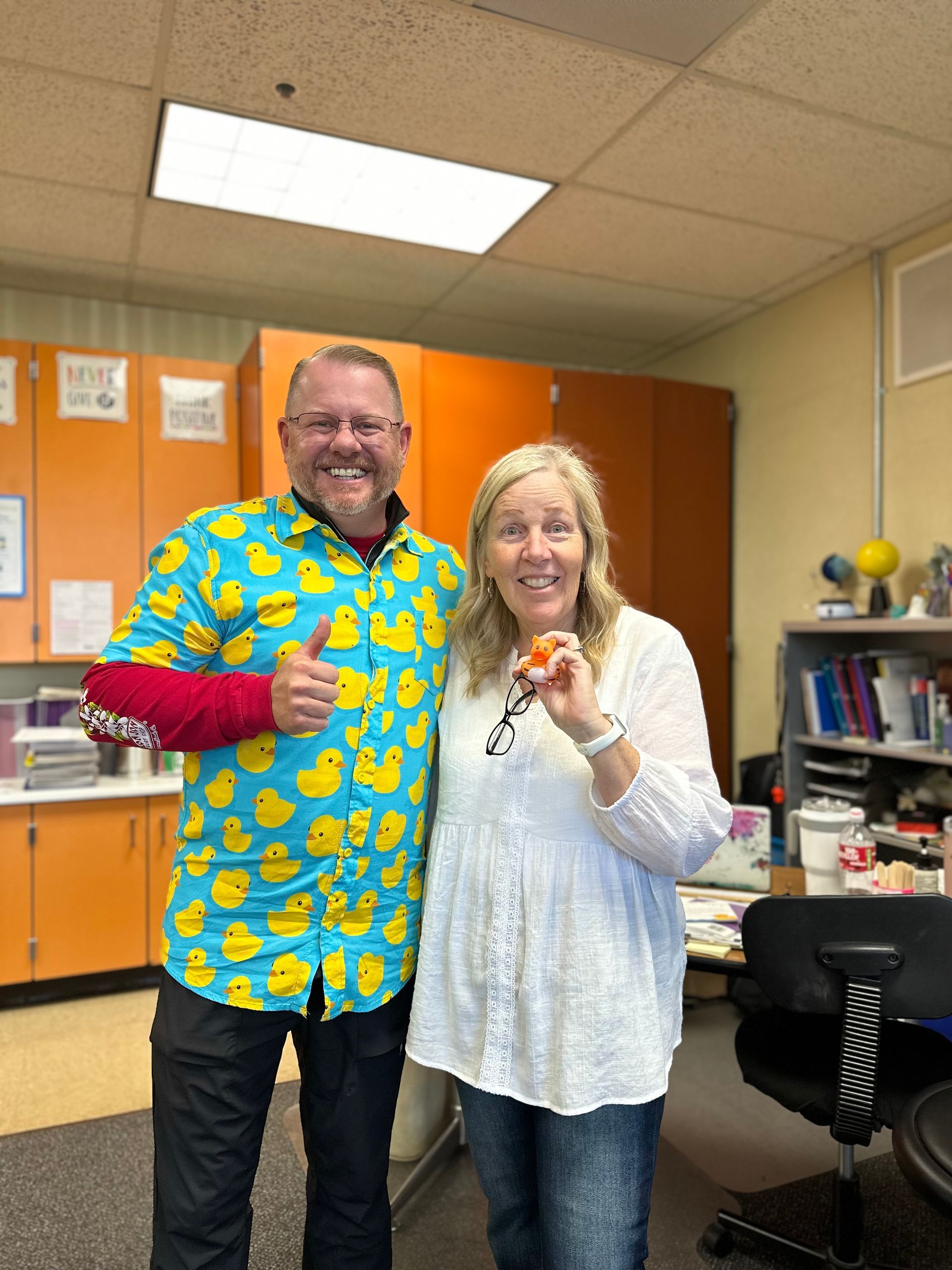 A man in a duck shirt stands next to a woman holding a key