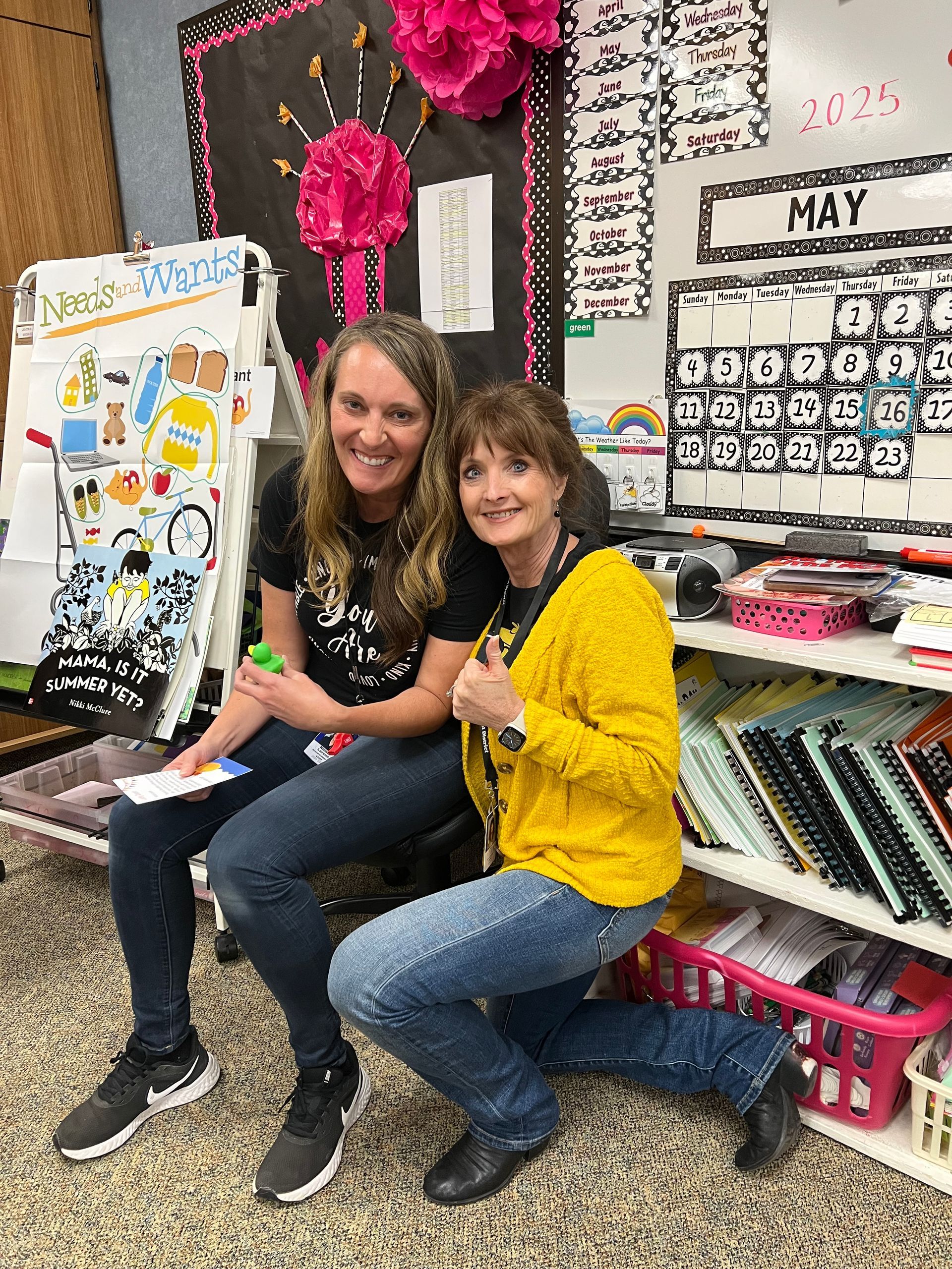 Two women are sitting next to each other in a classroom.