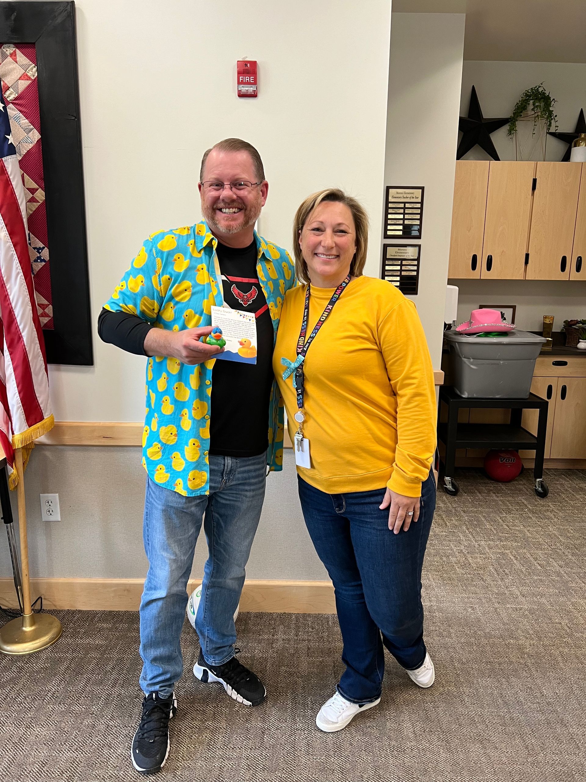 A man in a yellow shirt is standing next to a woman in a yellow sweater.