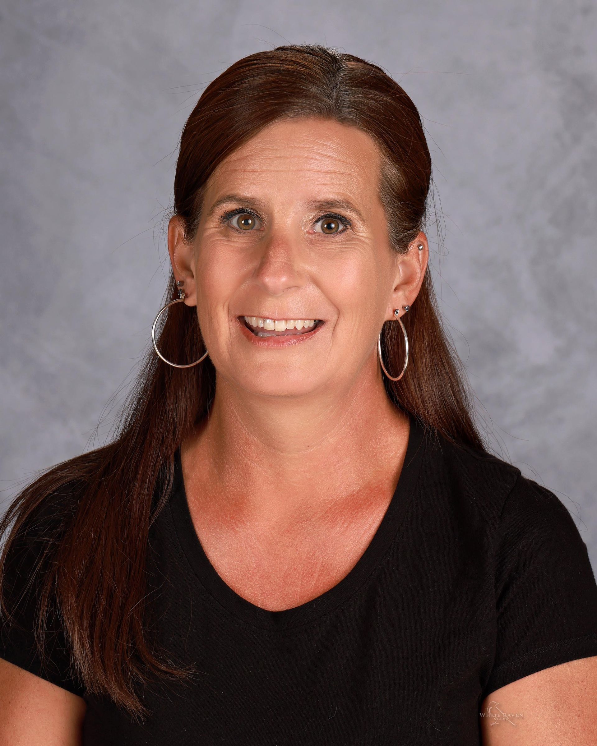 A sign that says `` coming soon '' next to a branch of eucalyptus leaves.