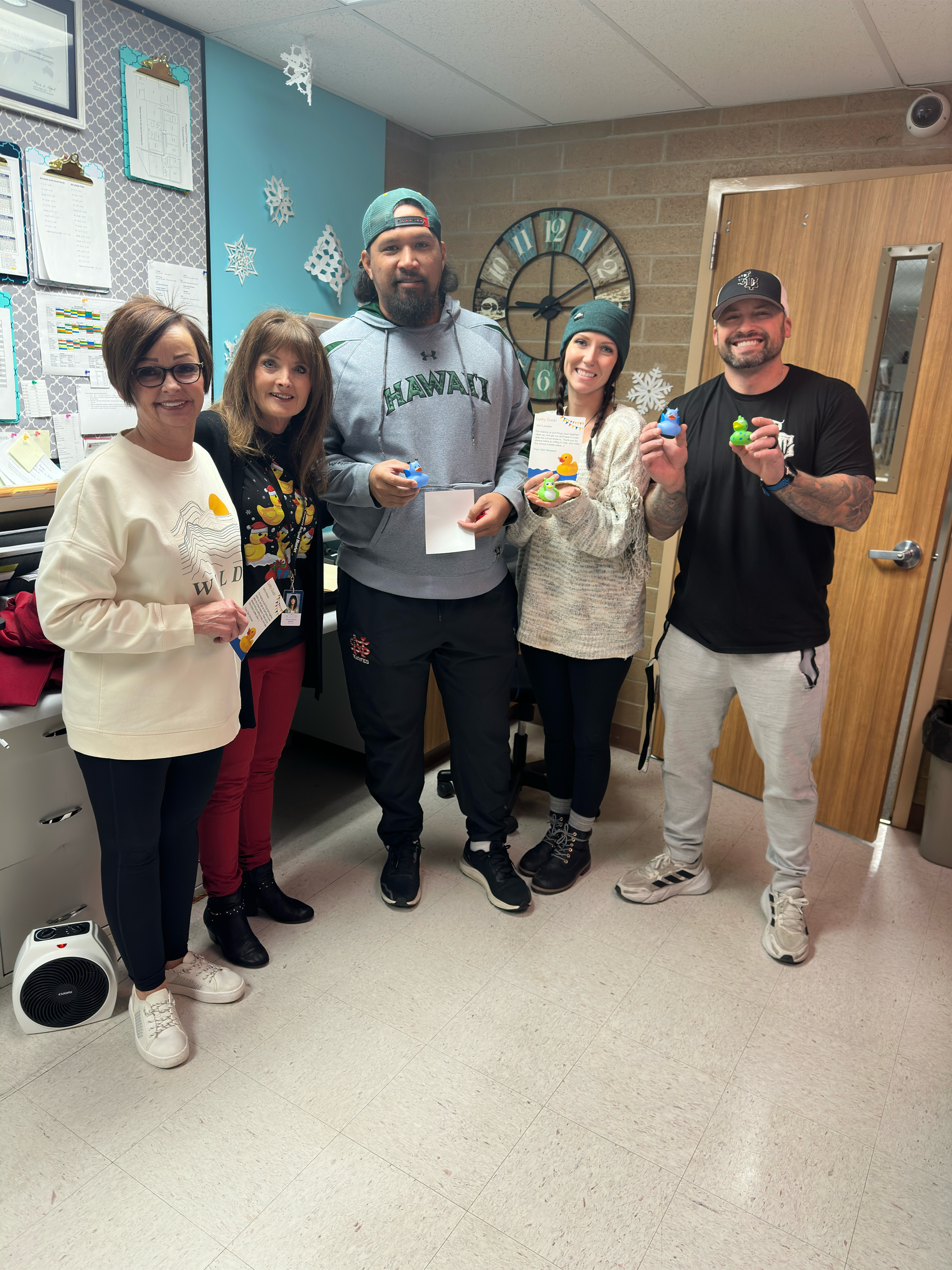 A group of people are standing in a room holding gifts.