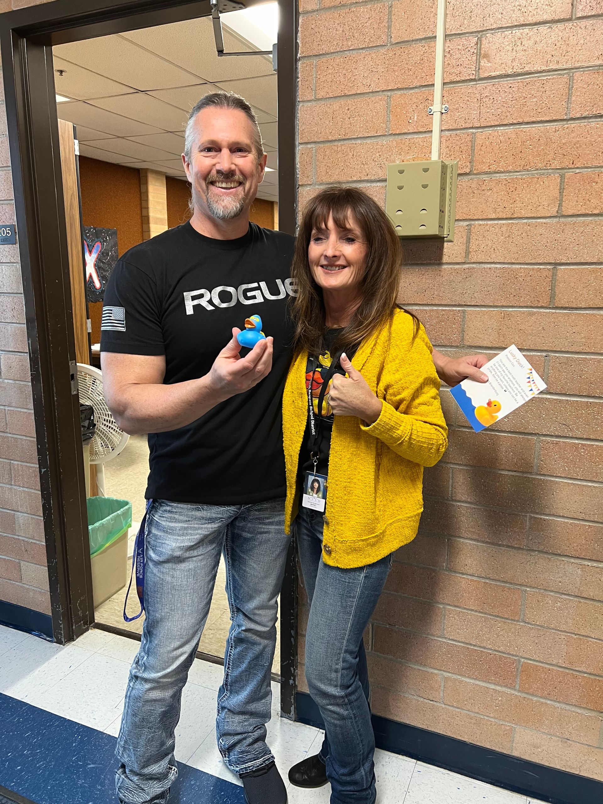 A man and a woman are standing next to each other in a hallway.