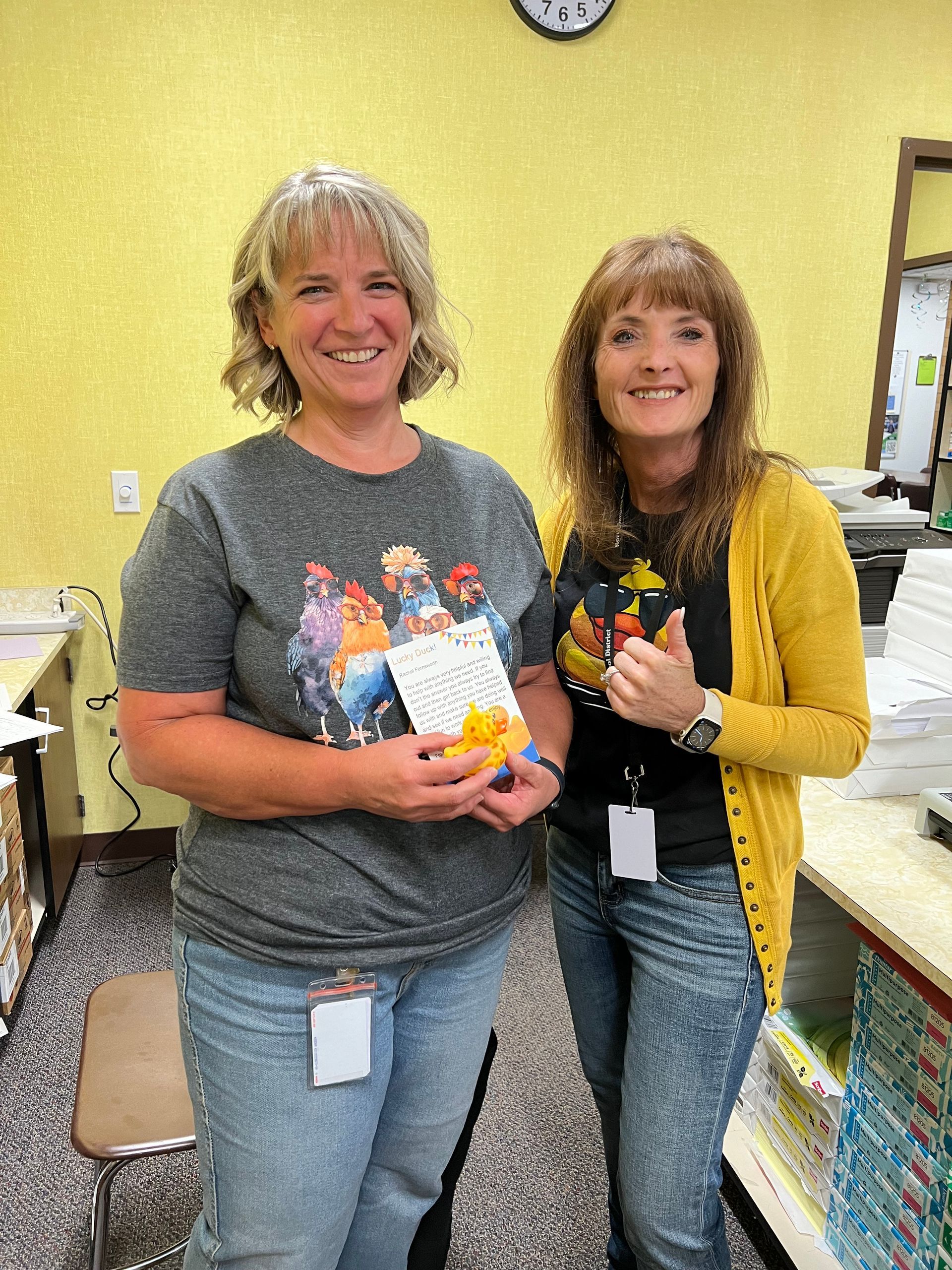 Two women are standing next to each other in a store holding a card.