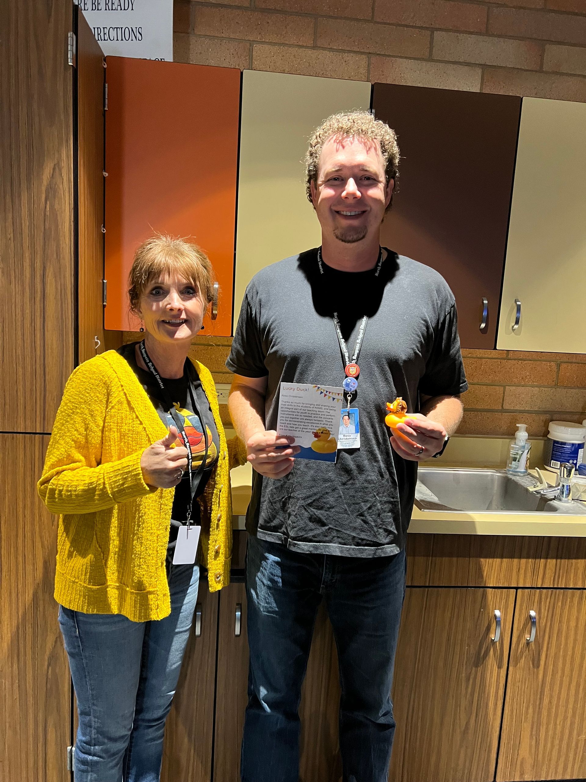 A man and a woman are standing next to each other in a kitchen.