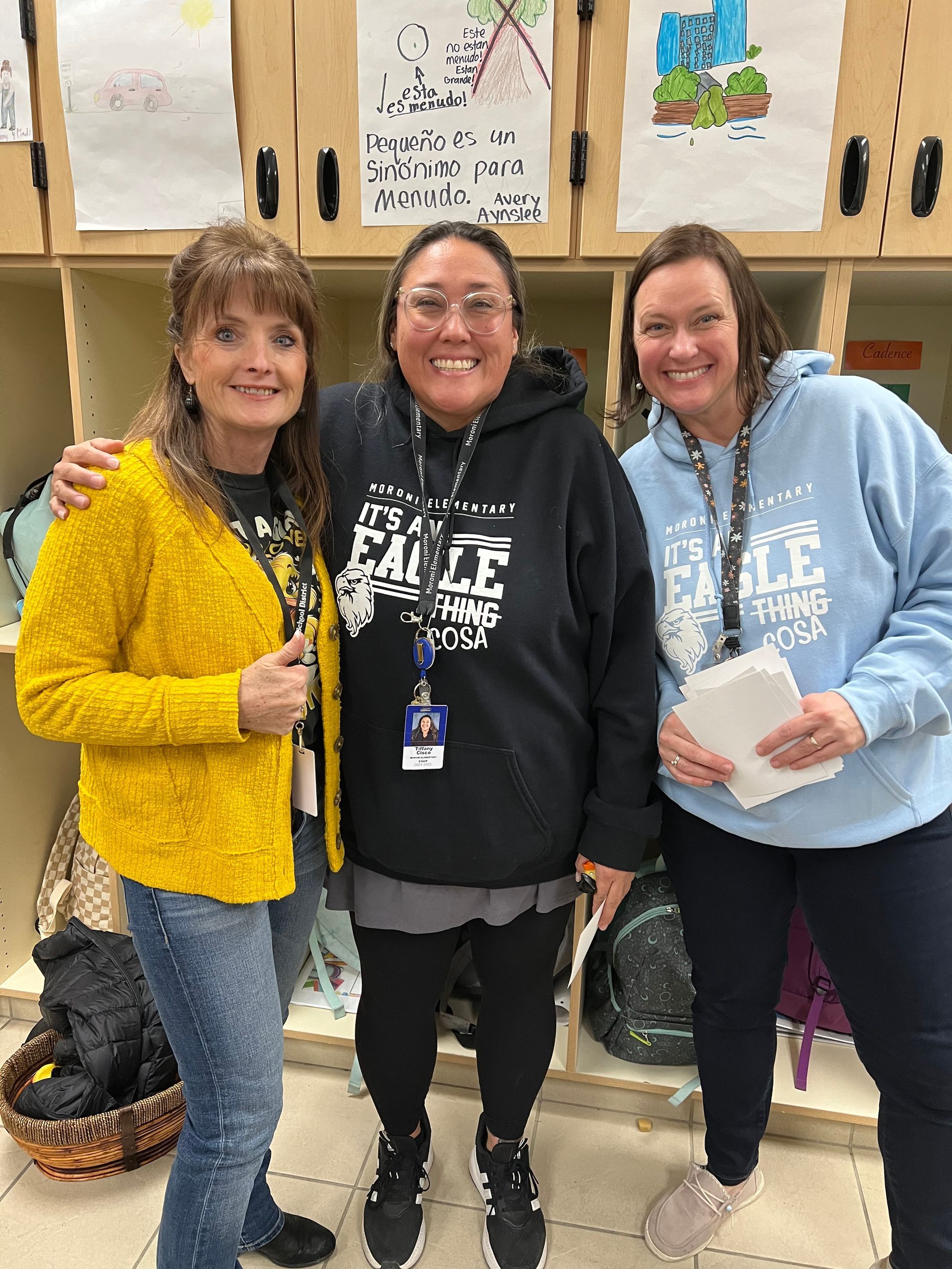 Three women are posing for a picture in a locker room.