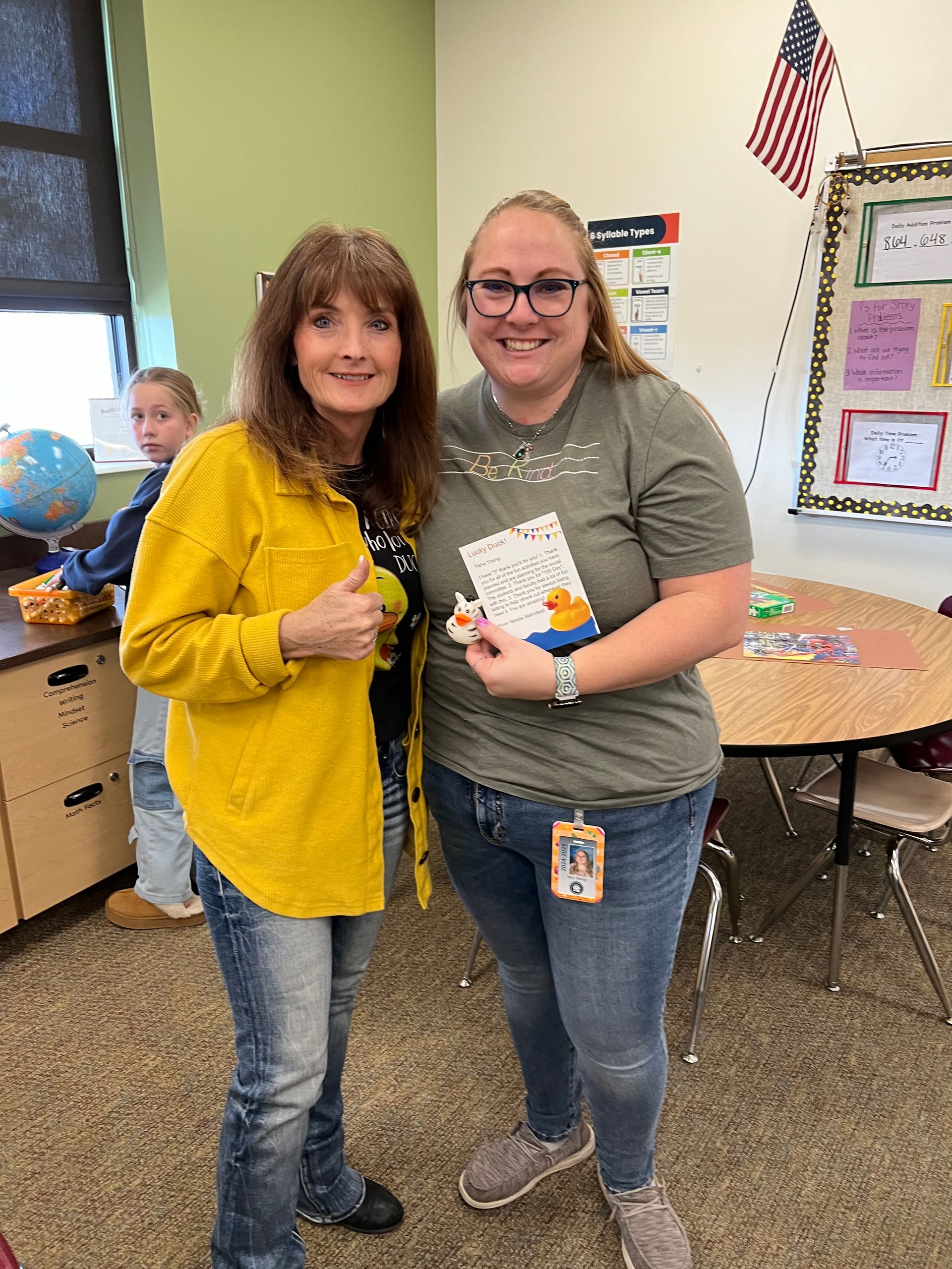 Two women are standing next to each other in a classroom.