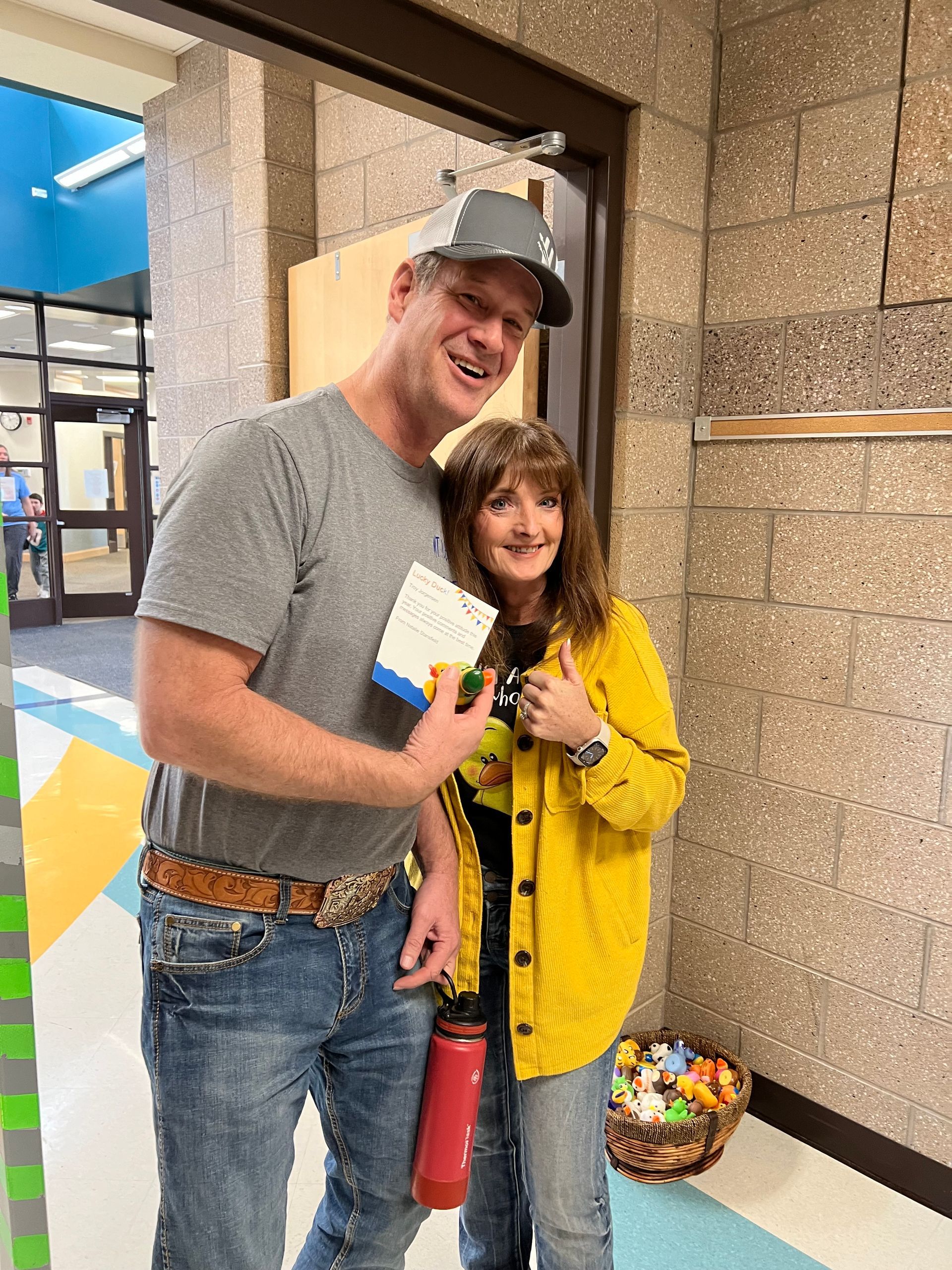 A man and a woman are standing next to each other in a hallway.