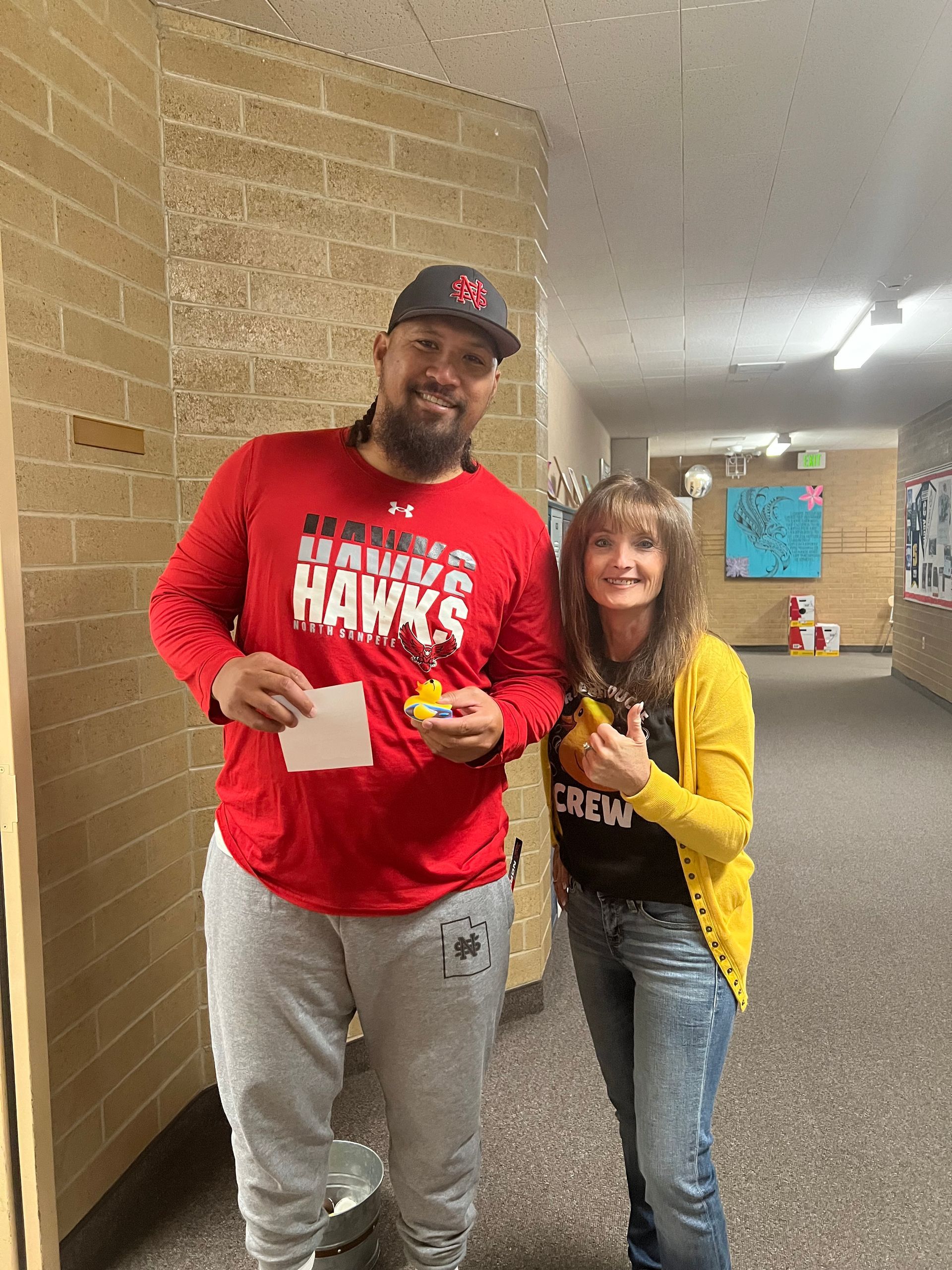 A man and a woman are standing next to each other in a hallway.