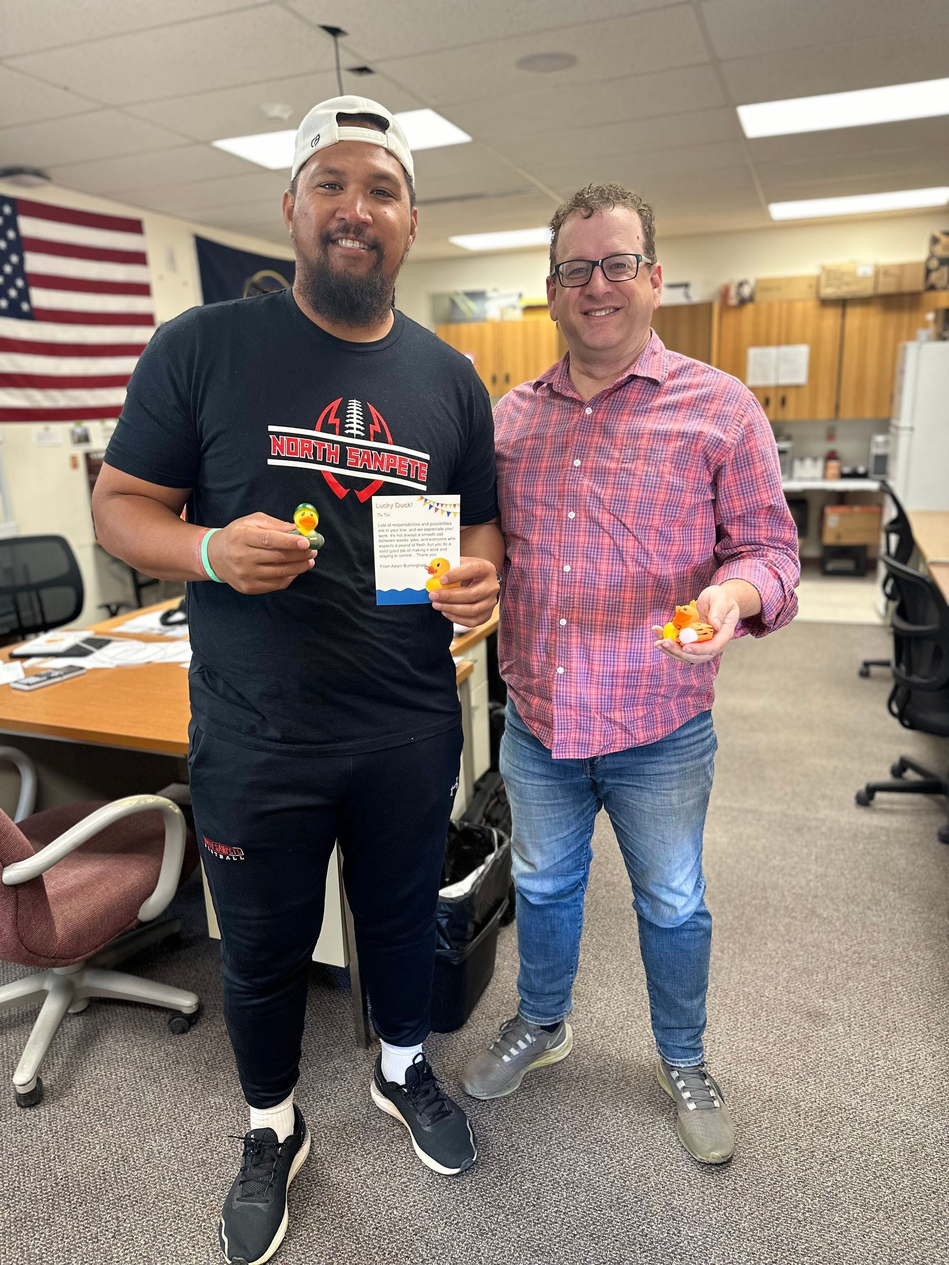 Two men are standing next to each other in an office.